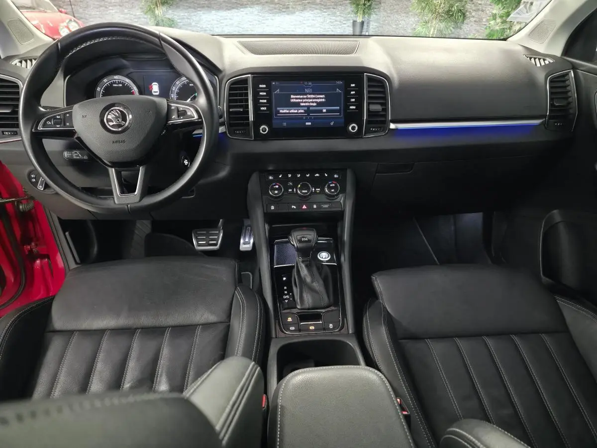Intérieur noir du Skoda Karoq 2018, vue frontale sur tableau de bord, volant cuir multifonction et console centrale DSG7.