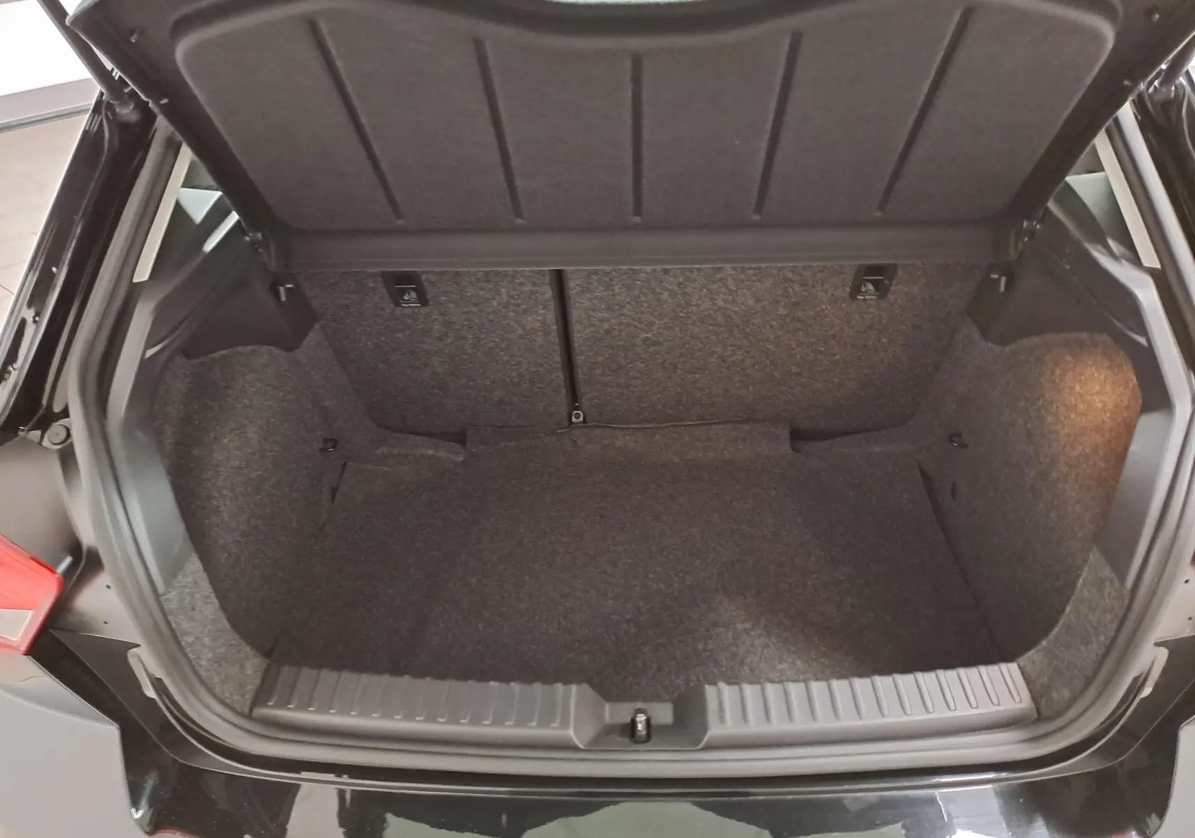 Coffre ouvert vu de dessus d’une SEAT Ibiza 2024 noir minuit, montrant un espace de rangement propre et spacieux.