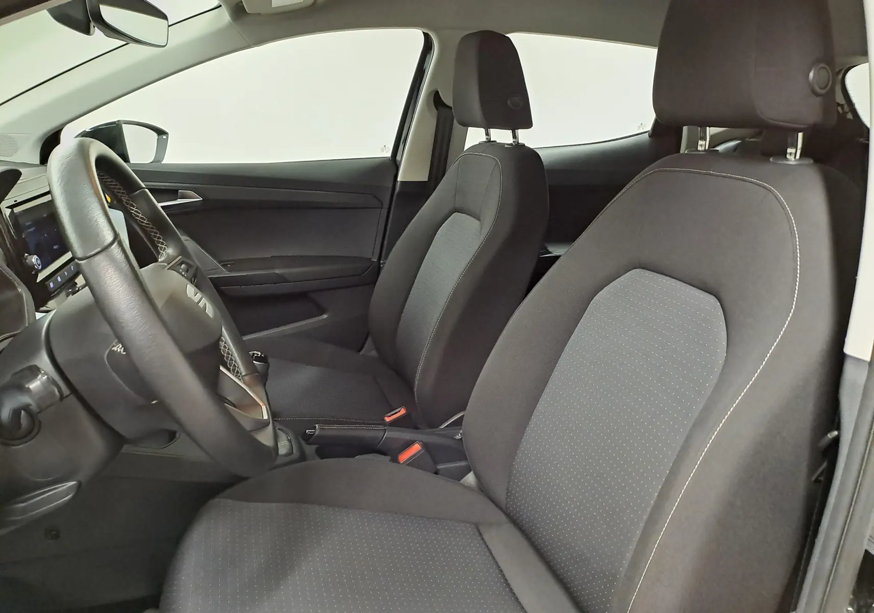 Vue intérieure côté conducteur de la SEAT Ibiza 2024 noir minuit, avec sièges tissu et volant multifonction.