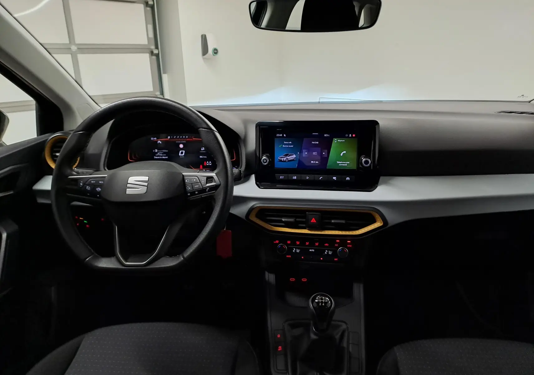 Vue intérieure frontale du tableau de bord de la SEAT Ibiza 2024 noir minuit avec écran tactile et levier de vitesses manuel.