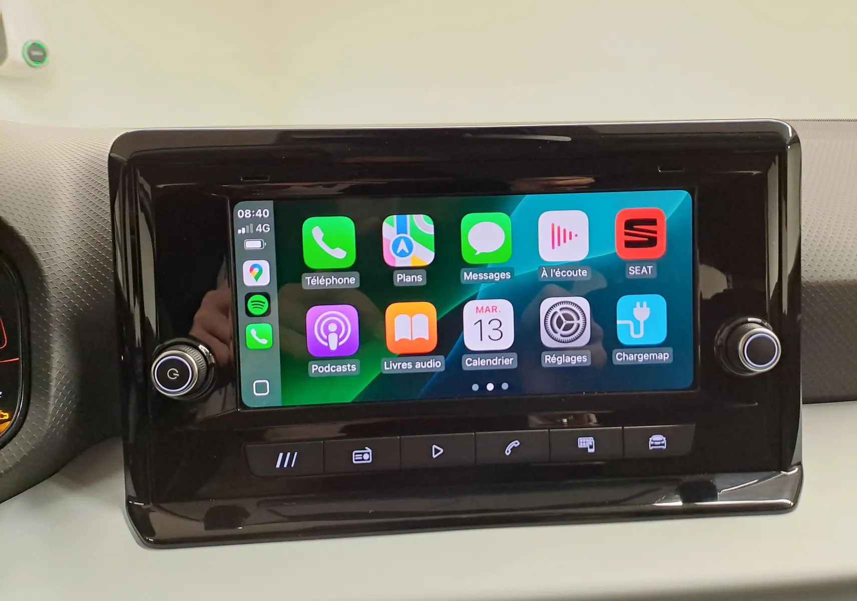 Écran tactile central de la SEAT Ibiza 2024 affichant Apple CarPlay avec interface colorée et boutons de contrôle noirs.