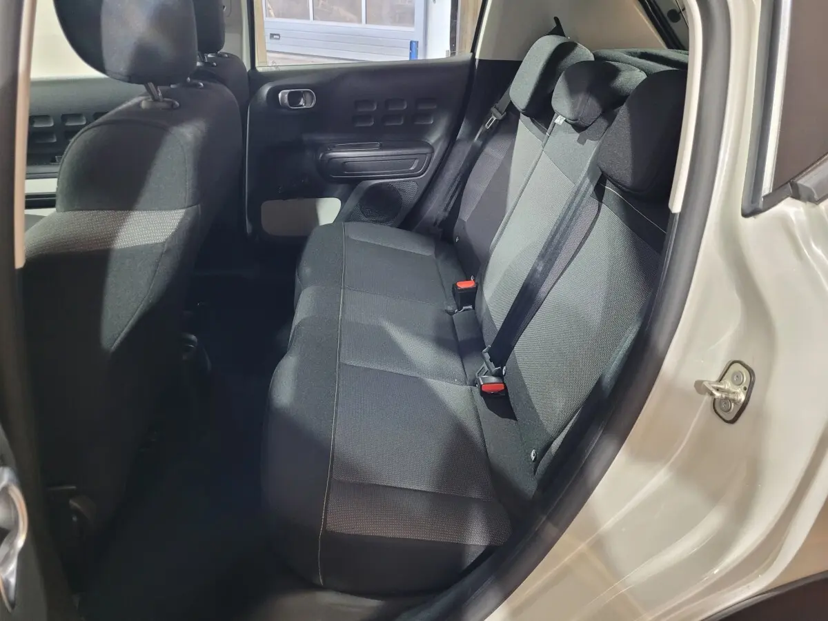 Vue intérieure côté droit sur la banquette arrière noire de la Citroën C3 beige PureTech 83 Feel Pack 2022.