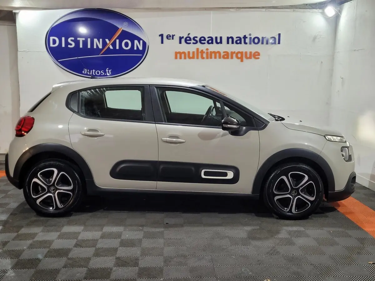 Vue de profil côté gauche d'une Citroën C3 beige 2022 avec protections latérales noires et jantes alliage.