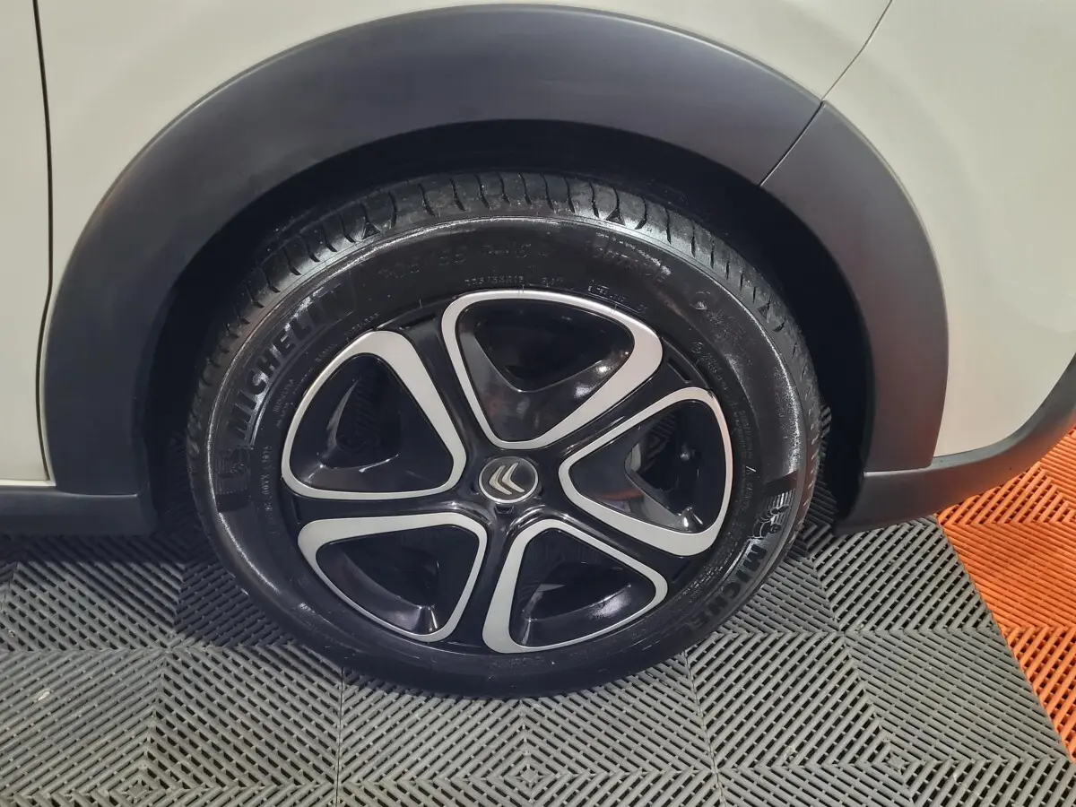 Gros plan sur la roue avant droite beige d'une Citroën C3 2022 avec jante noire et inserts argentés.