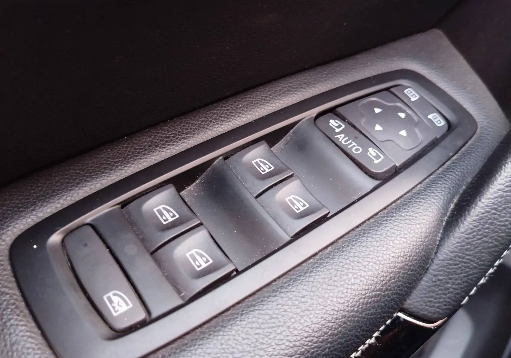 Gros plan sur les commandes des vitres électriques et des rétroviseurs côté conducteur du Renault Kadjar 1.3 TCe 140ch gris Titanium.