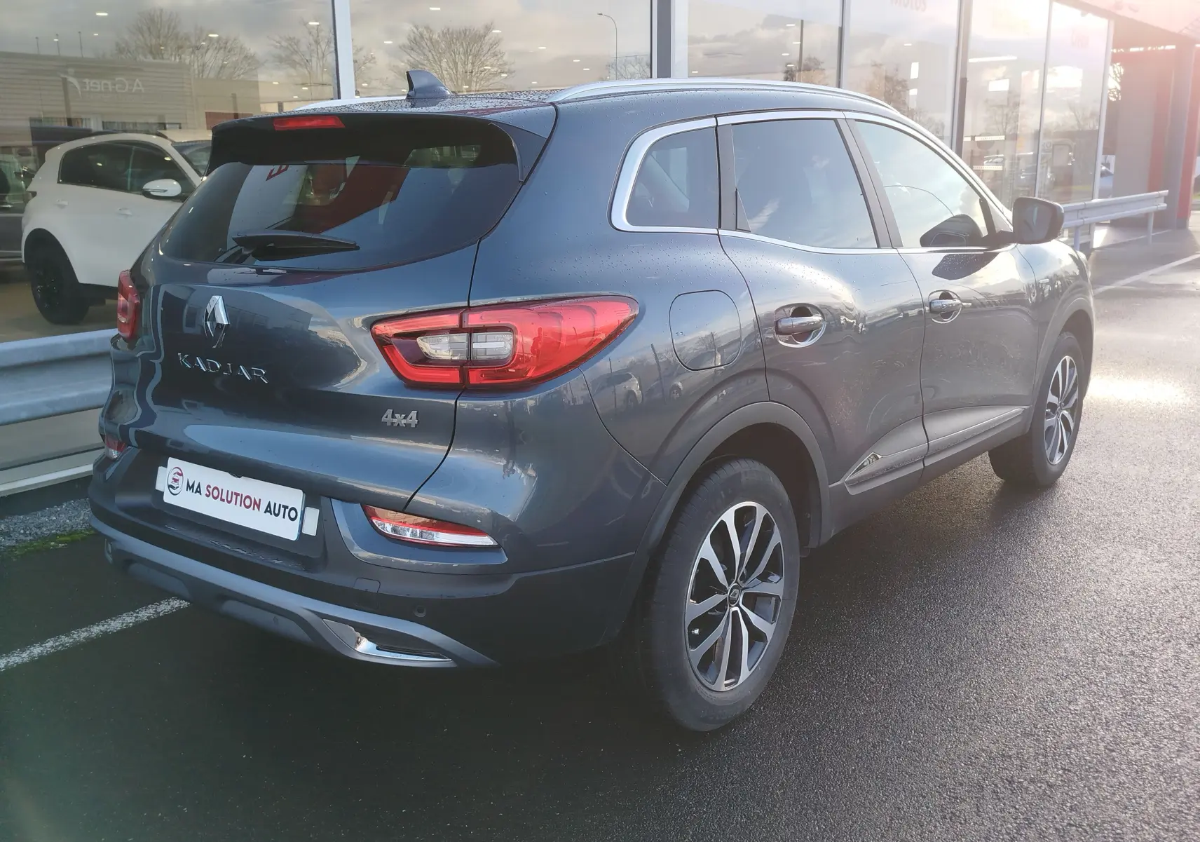 Vue 3/4 arrière droite d'un Renault Kadjar gris titanium 2021 avec badge 4x4 et jantes bi-ton.