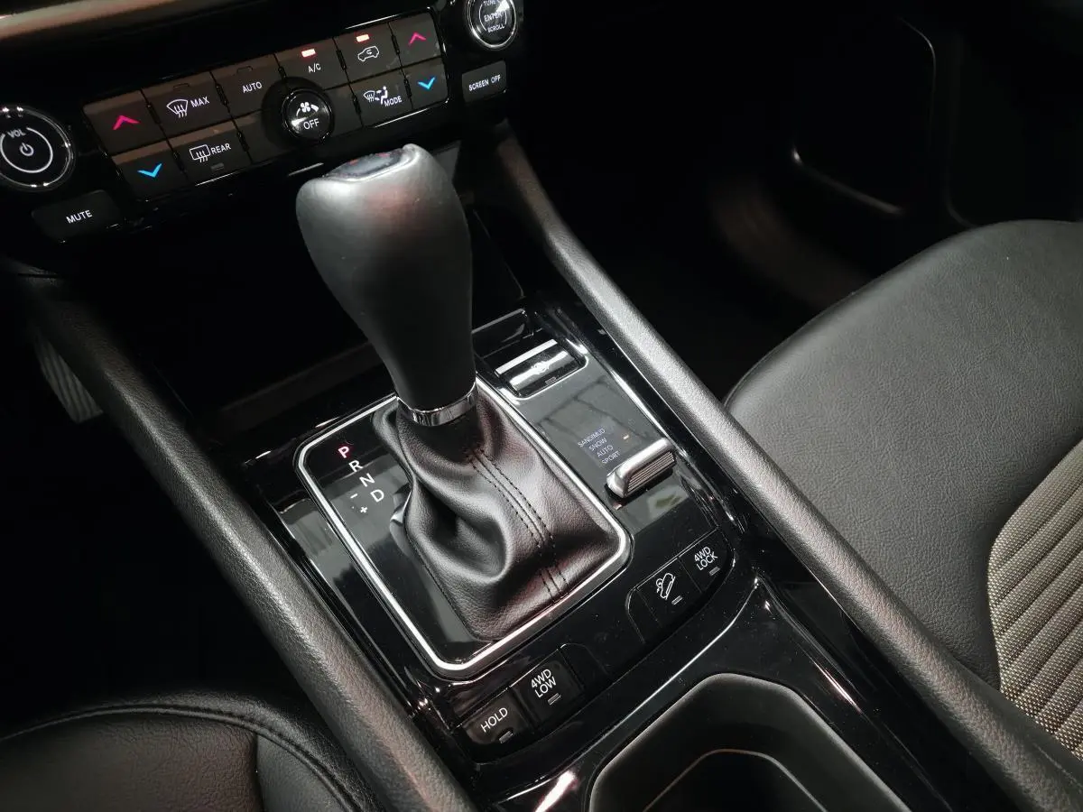 Gros plan sur la console centrale noire du Jeep Compass 2024 avec levier de vitesse automatique et commandes 4WD visibles.