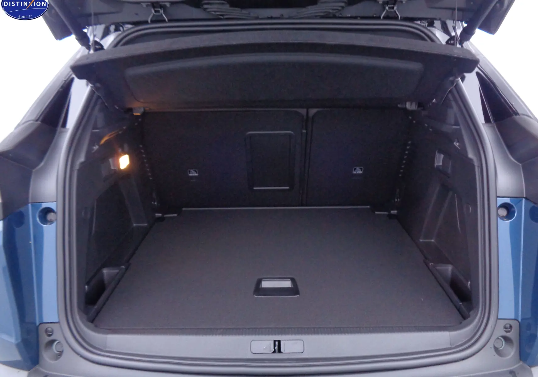 Coffre ouvert d'un Peugeot 3008 2023 bleu Célèbes Métal, vue arrière montrant l'espace de chargement vide et bien fini.