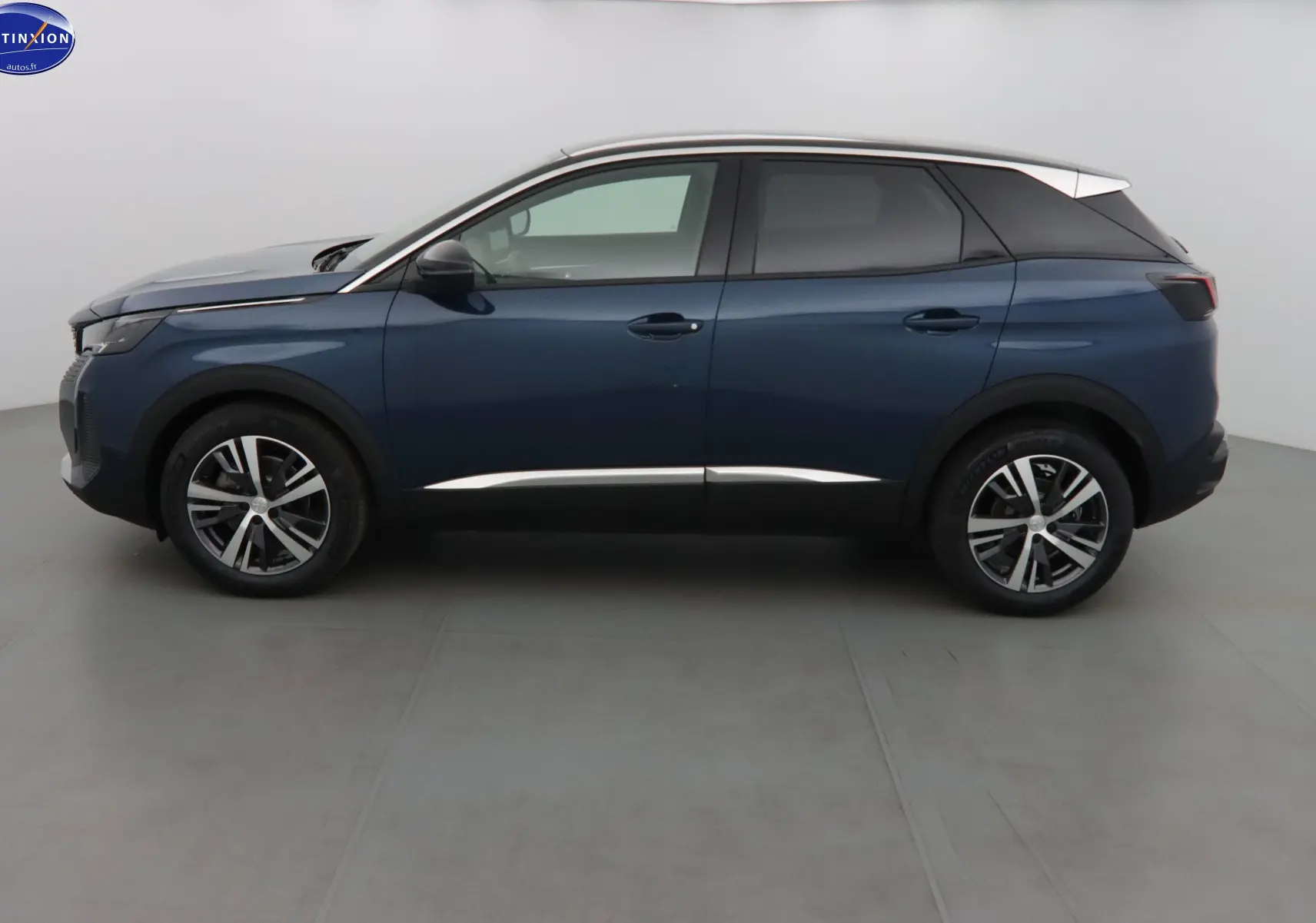 Profil côté gauche d'un Peugeot 3008 2023 bleu Célèbes métallisé avec toit blanc et jantes alliage bicolores.