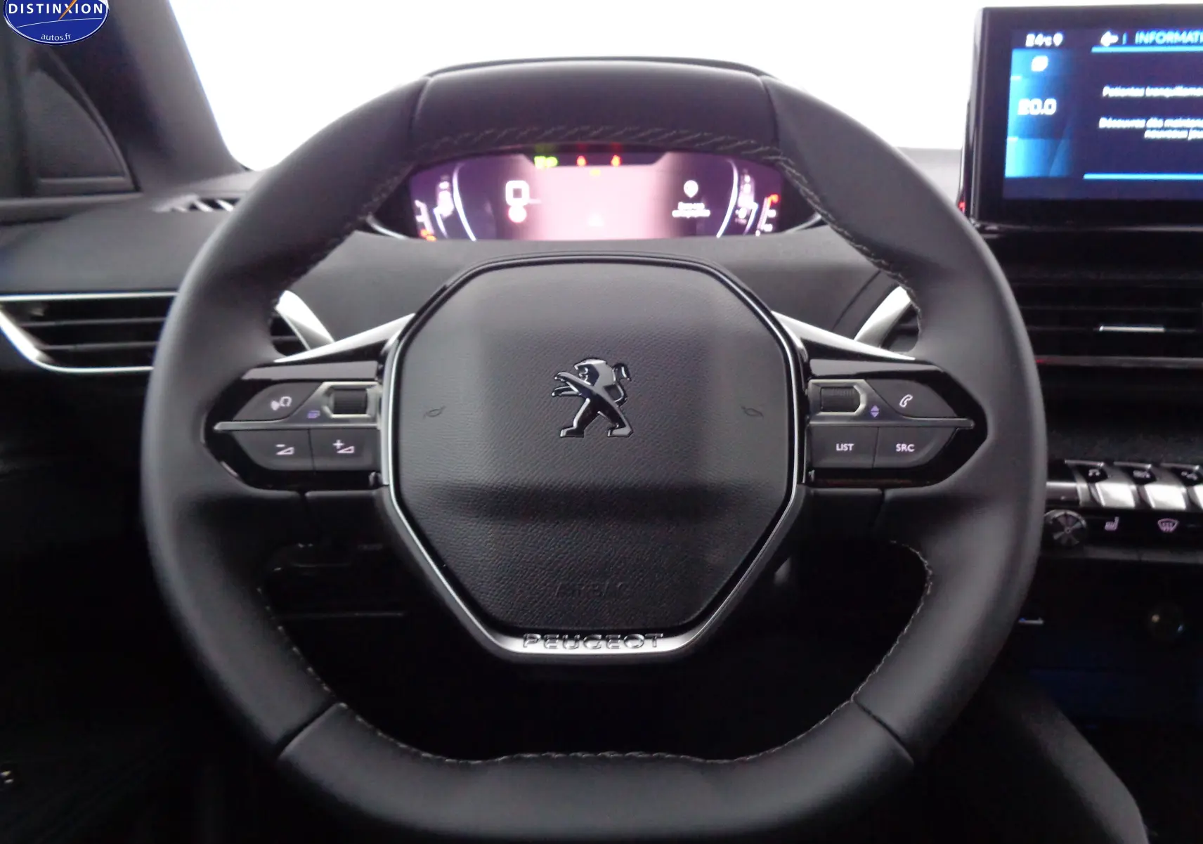 Vue rapprochée du volant cuir noir du Peugeot 3008 2023 avec commandes intégrées et tableau de bord numérique.