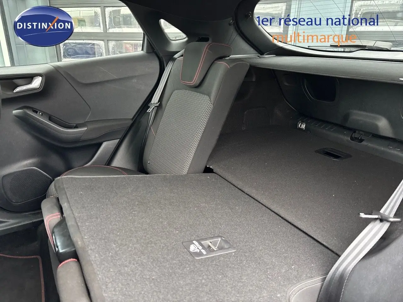 Vue intérieure arrière du Ford Puma gris Solar montrant les sièges rabattus et l'espace de chargement étendu.