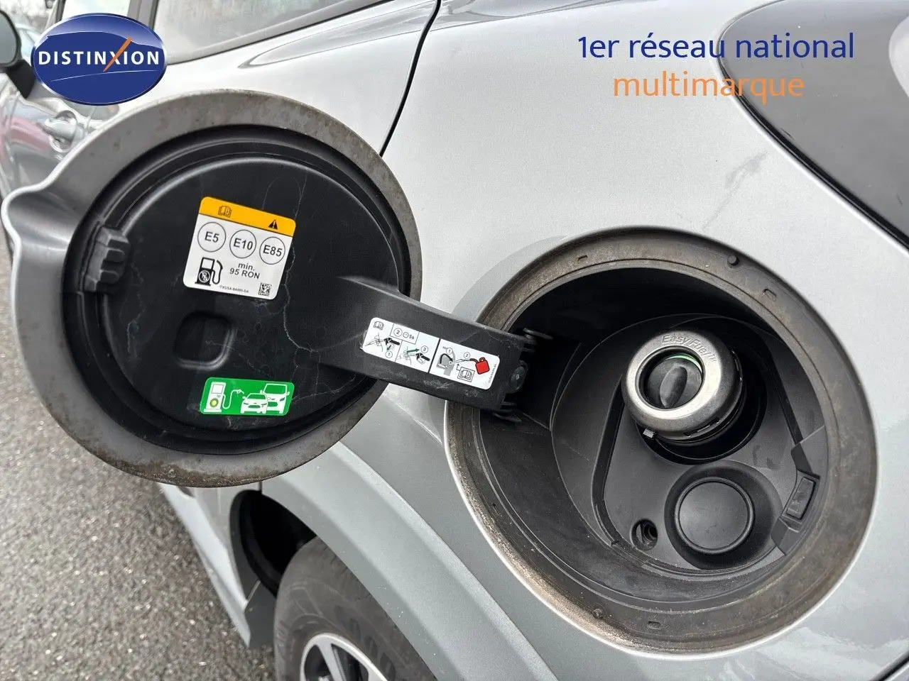 Gros plan sur la trappe à carburant côté gauche d'un Ford Puma gris Solar 2022, avec bouchon ouvert et étiquettes bioéthanol visibles.