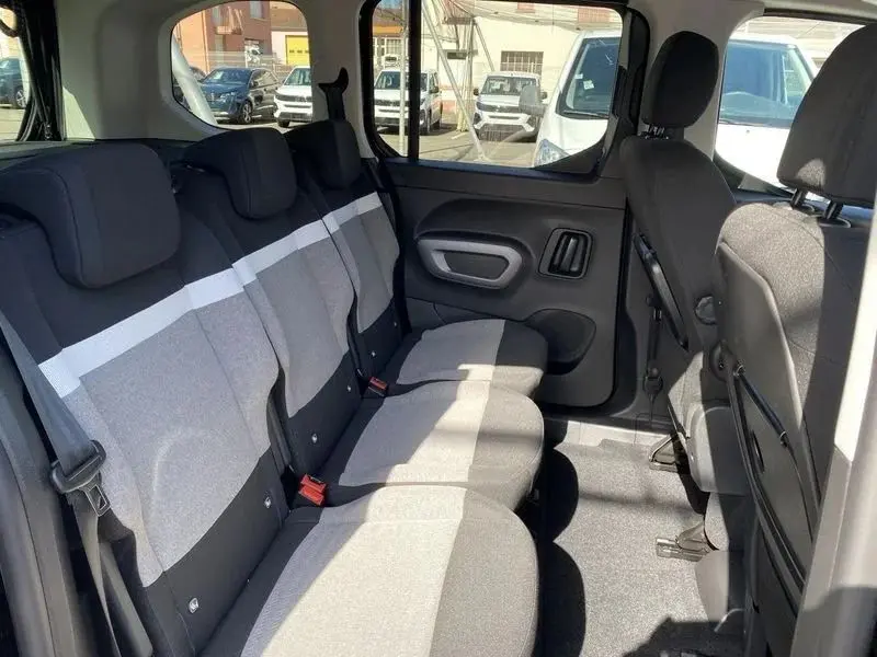 Vue intérieure côté droit des sièges arrière gris clair et foncé du Citroën Berlingo Taille M 2025, avec appuie-têtes et ceintures visibles.