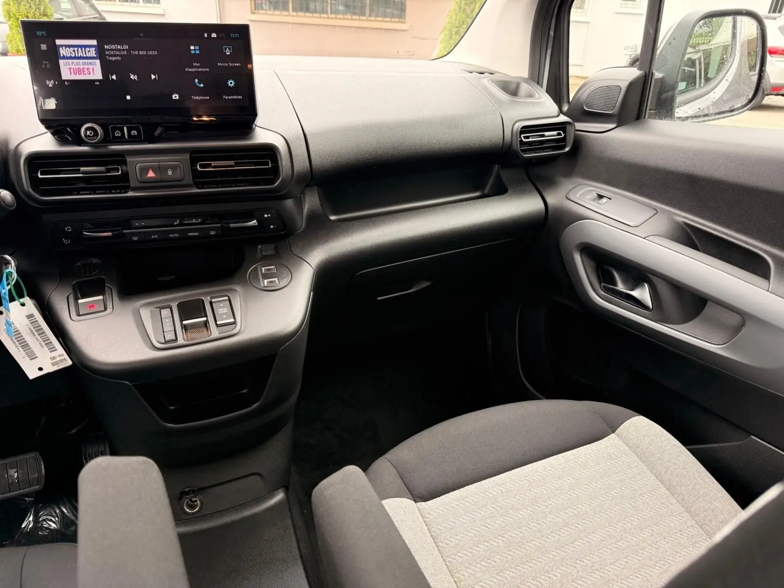 Vue intérieure côté passager du Citroën Berlingo 2025 gris, montrant la planche de bord et la console centrale moderne.