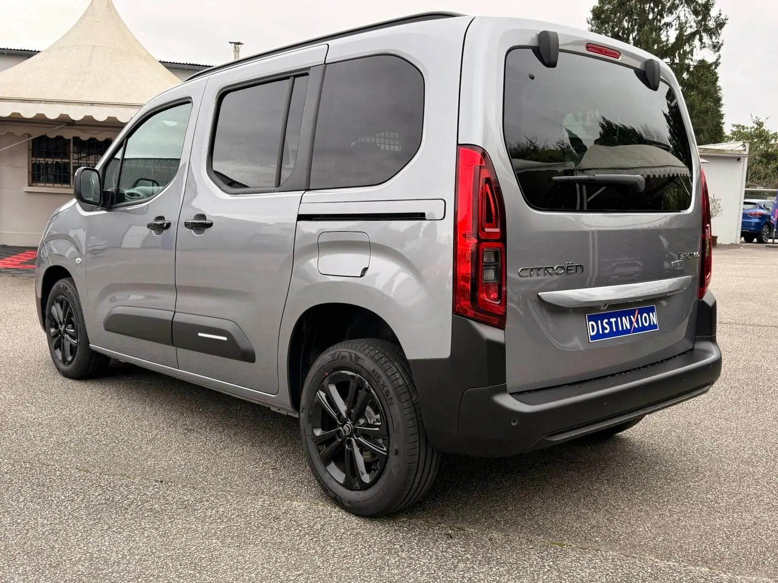 Vue 3/4 arrière droit du Citroën Berlingo gris Artense avec vitres teintées et jantes noires.