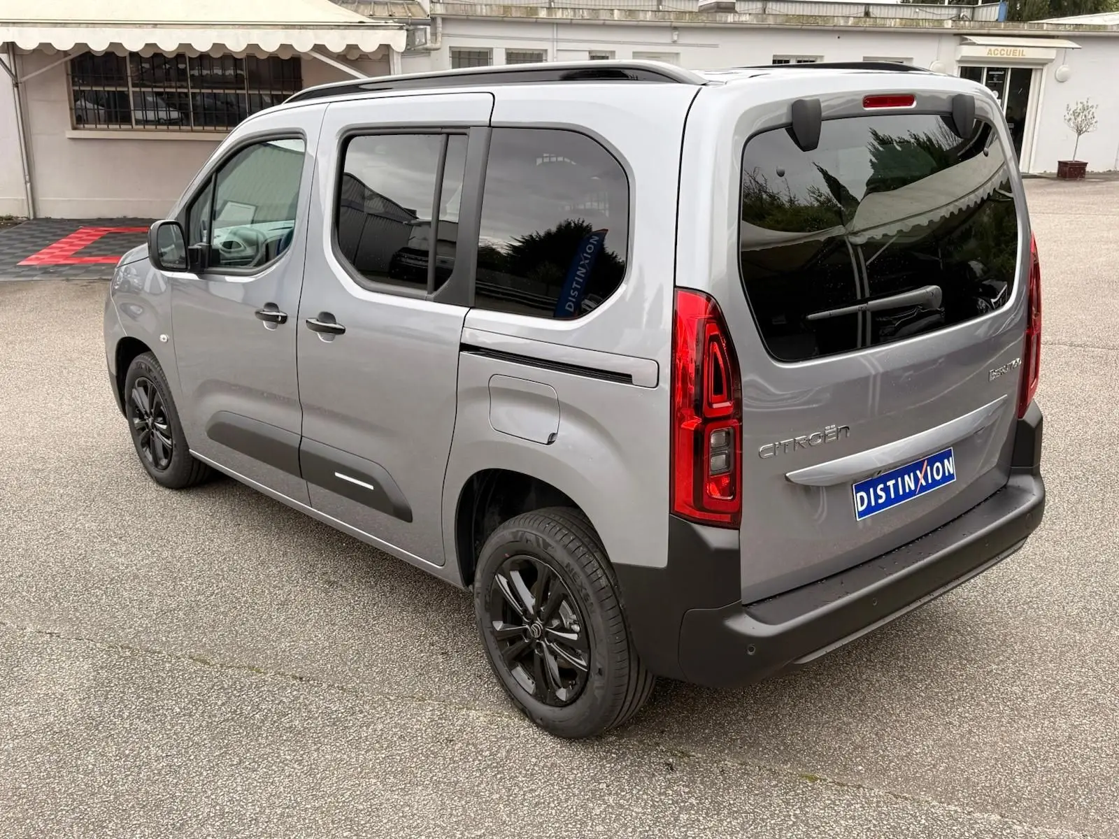 Vue 3/4 arrière côté gauche du Citroën Berlingo gris Artense 2025 avec vitres teintées et jantes noires.