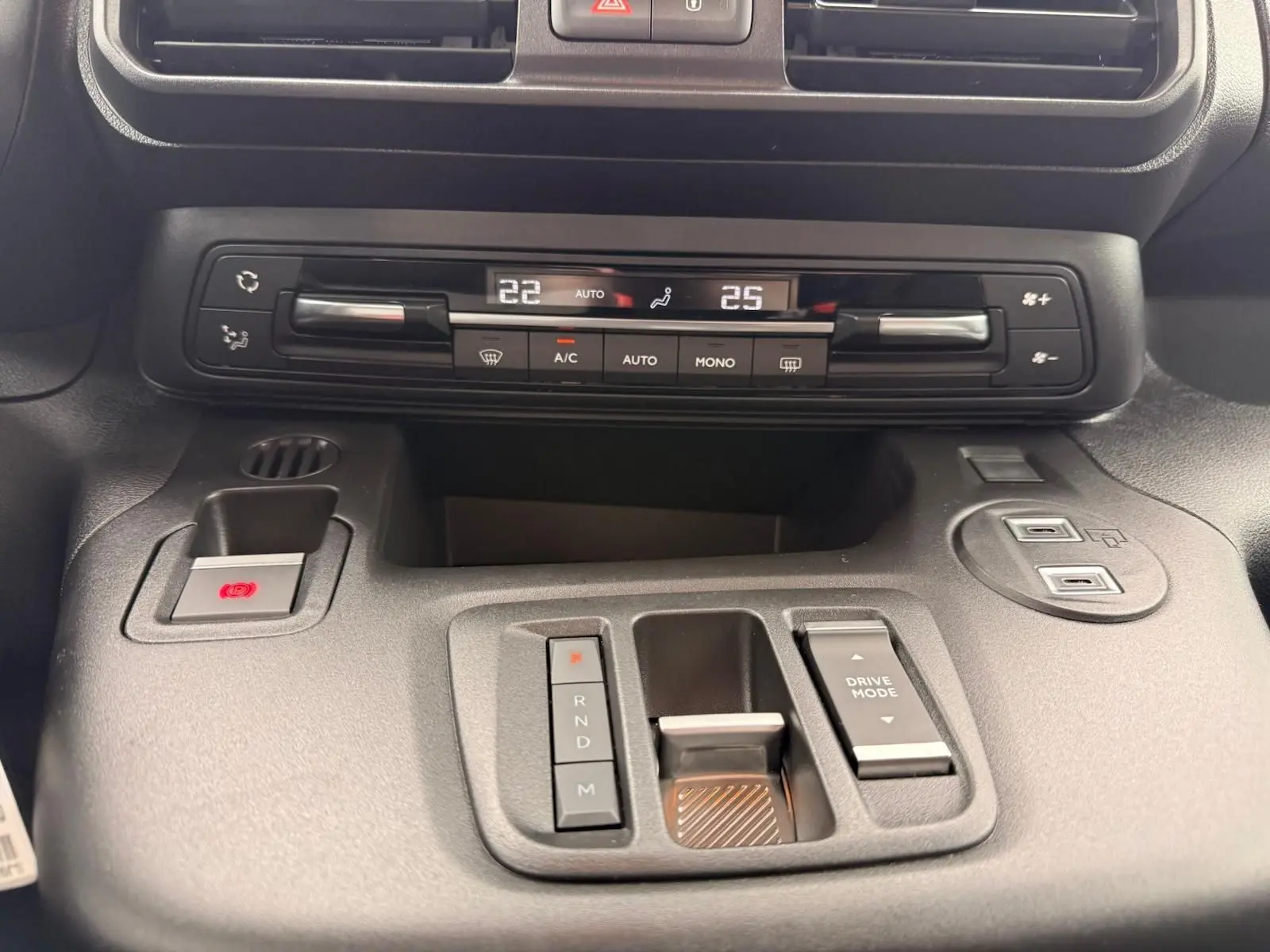 Vue rapprochée du tableau de bord gris du Citroën Berlingo 2025, montrant la climatisation digitale et la commande de boîte automatique.