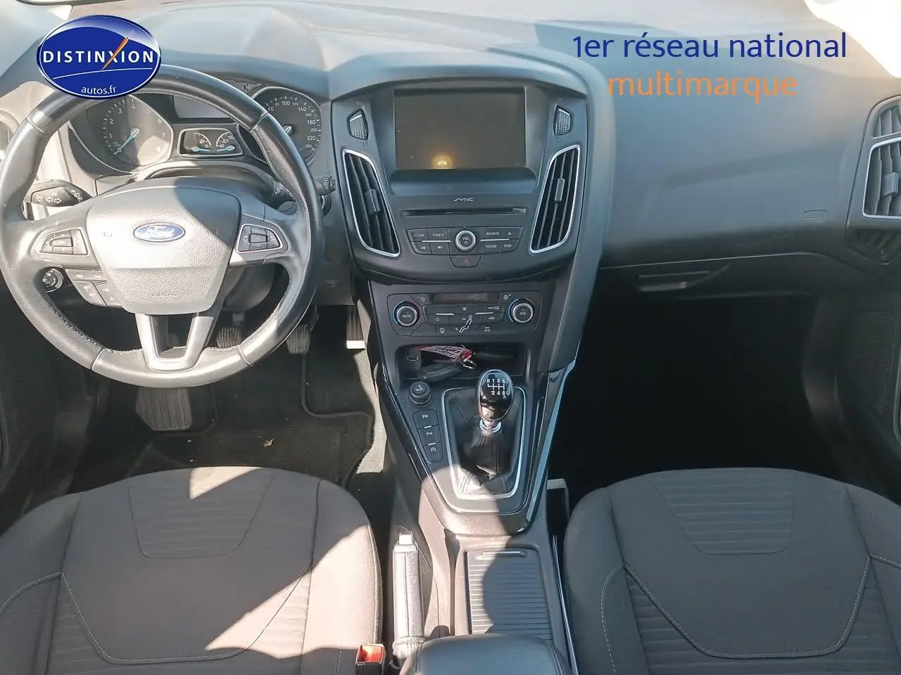 Vue intérieure avant de la Ford Focus 1.0 Ecoboost 125 Titanium 2017, volant cuir et console centrale avec boîte manuelle.
