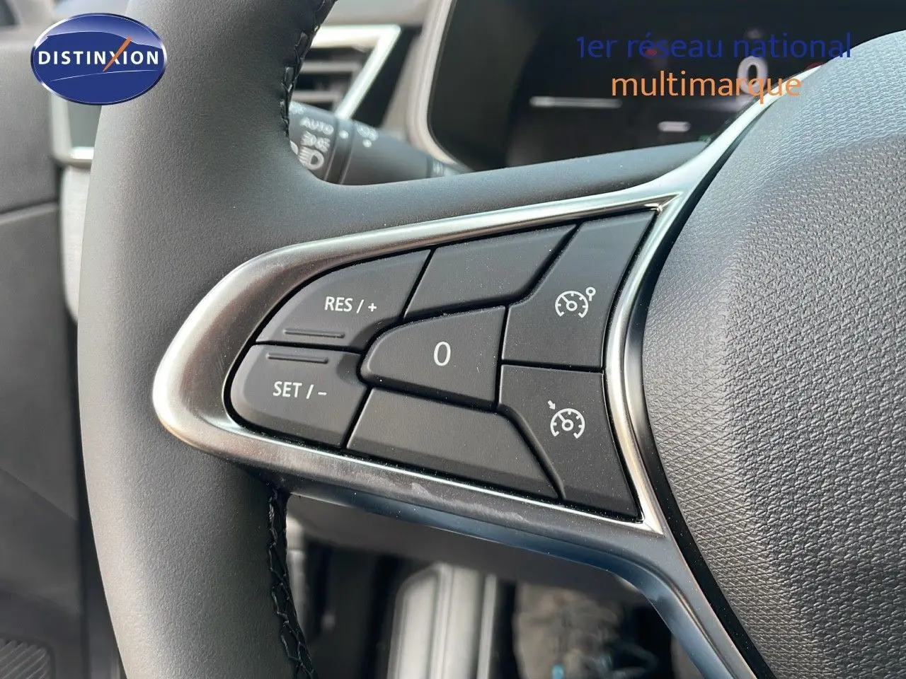 Gros plan sur les commandes de régulateur de vitesse au volant d'une Renault Clio gris schiste métal 2025.