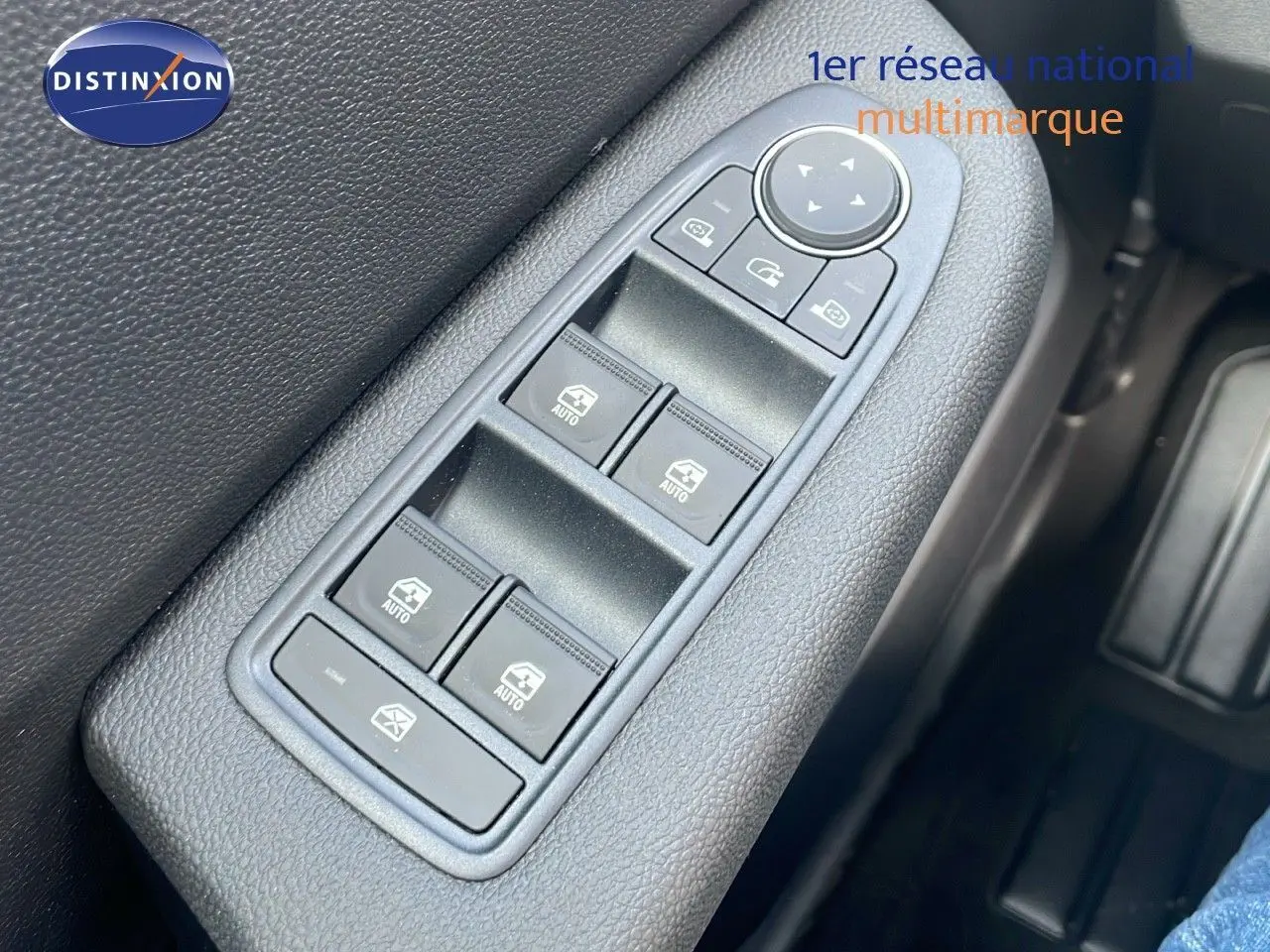 Gros plan sur les commandes des vitres électriques côté gauche d'une Renault Clio gris schiste métal 2025.