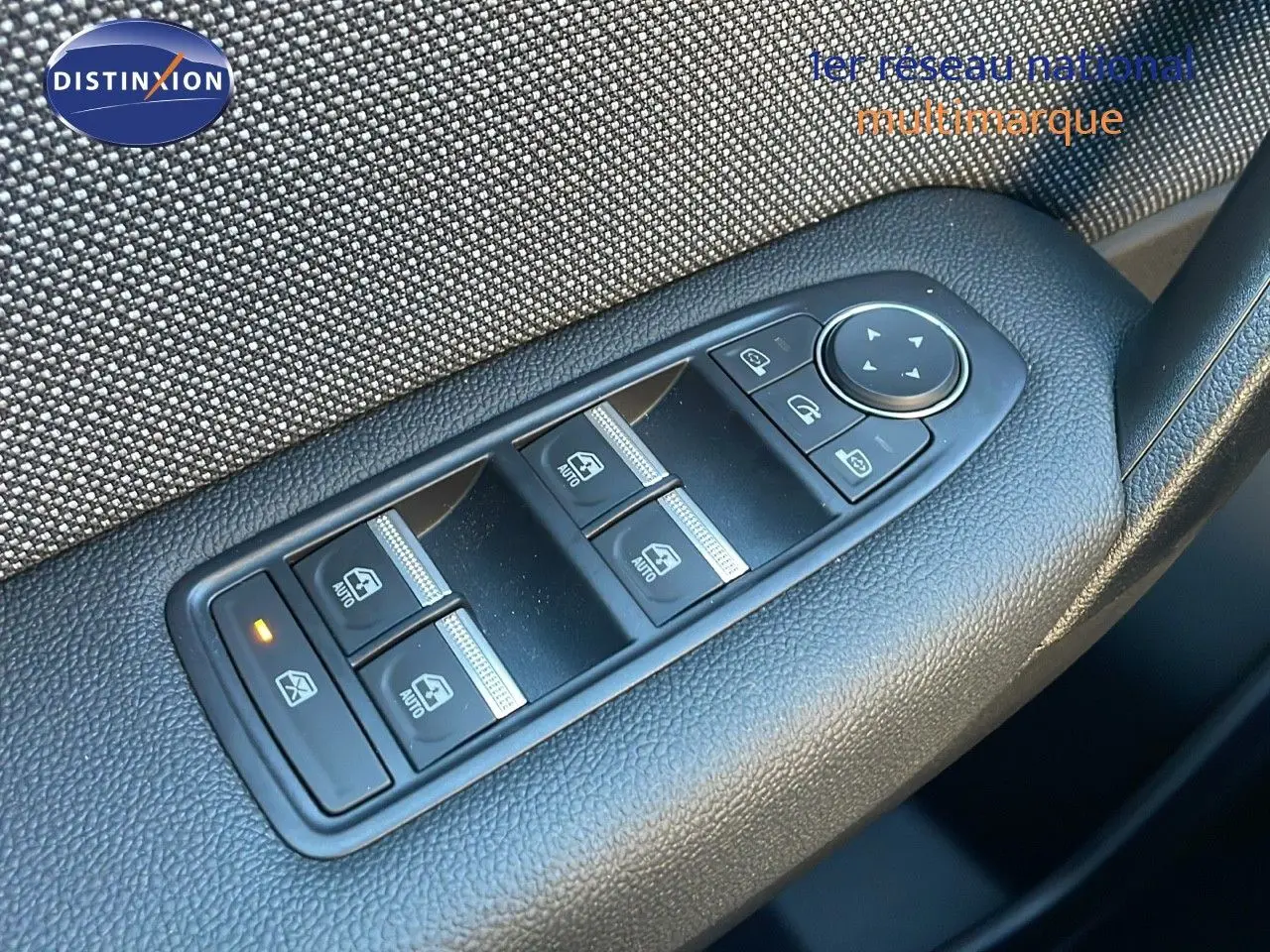 Gros plan sur les commandes des vitres électriques côté gauche du Renault Captur gris Cassiopée Métal 2025.