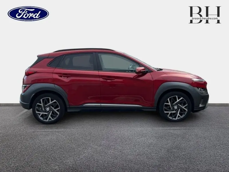 Vue de profil côté gauche du Hyundai KONA 2022 Pulse Red Métal avec jantes alliage et protections noires.