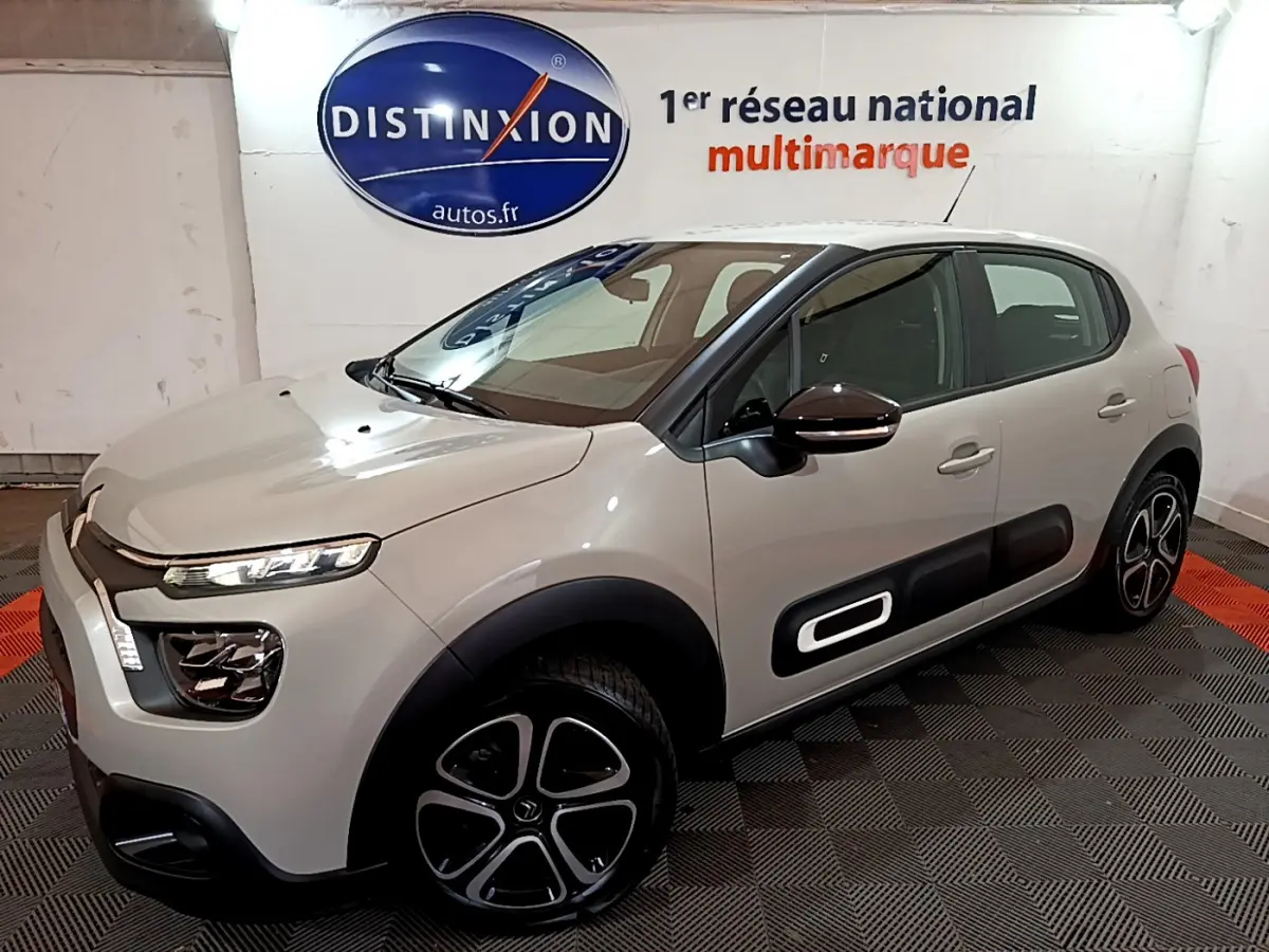 Citroën C3 beige vue 3/4 avant droit, avec protections latérales noires et jantes originales en alliage.