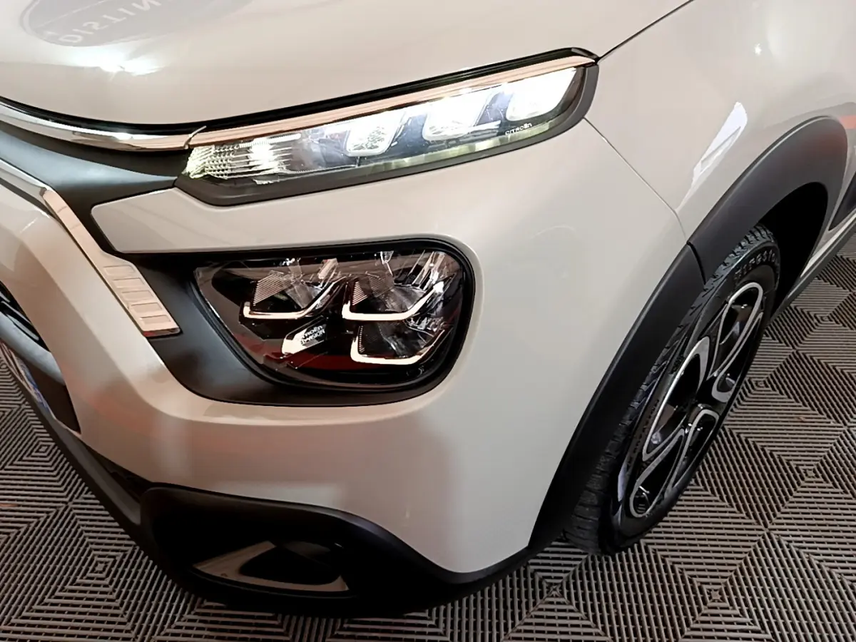 Gros plan sur l'avant droit beige de la Citroën C3 2022 avec phares LED et jante noire stylisée.