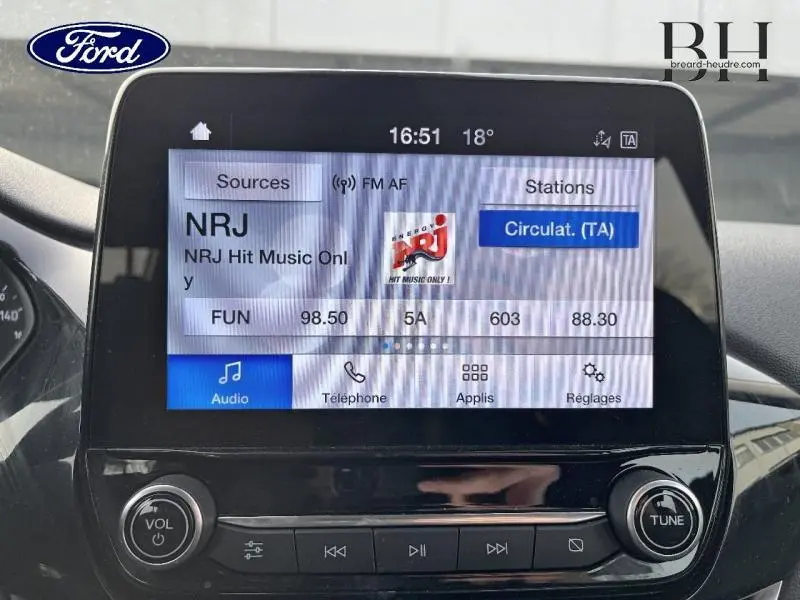 Écran tactile central de la Ford Fiesta 2020 affichant la radio NRJ, avec commandes audio et volume visibles.