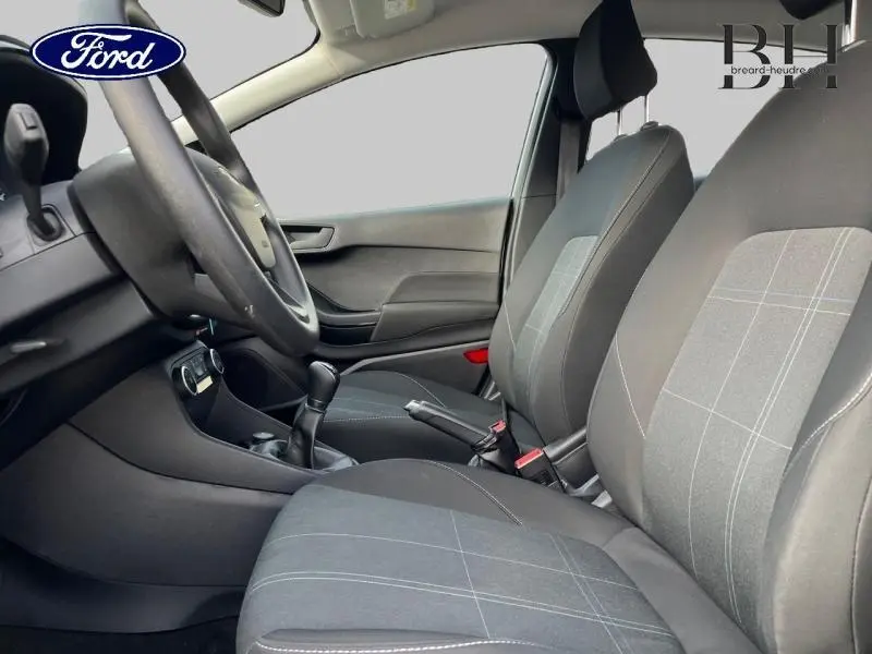 Vue intérieure côté conducteur de la Ford Fiesta 1.1 75ch Cool & Connect 2020 avec sièges tissu noir à motifs gris.