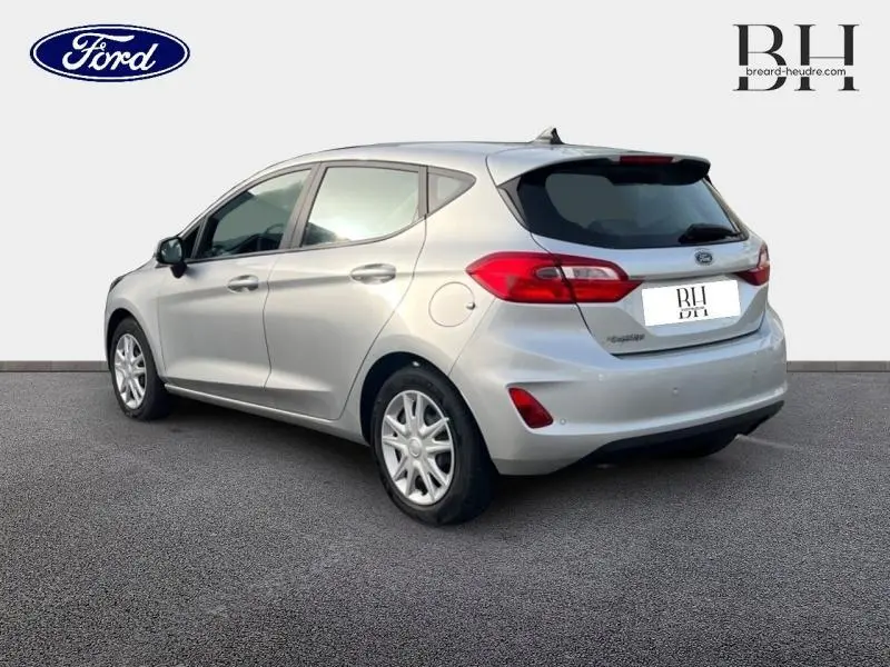 Vue 3/4 arrière droite d'une Ford Fiesta 2020 gris lunaire avec becquet et feux arrière rouges.