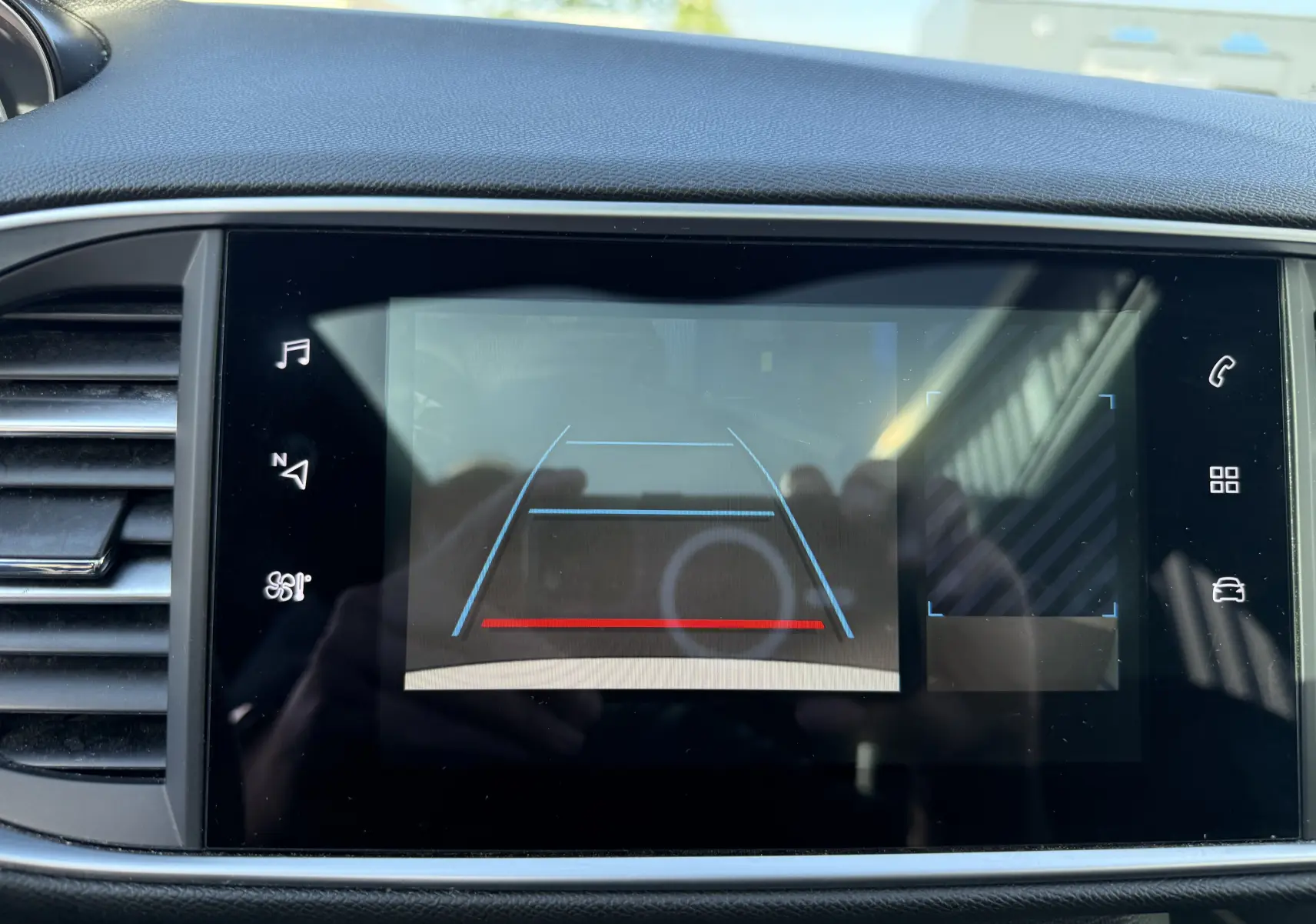 Écran tactile intérieur de la Peugeot 308 SW 2021 montrant la caméra de recul avec lignes de guidage colorées.