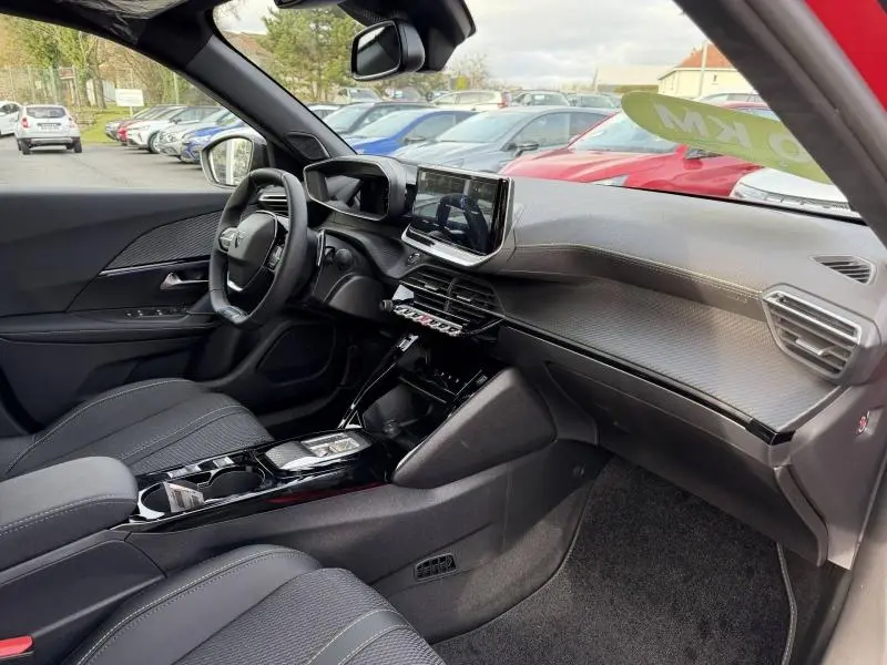 Intérieur avant droit du Peugeot 2008 1.2 Hybrid bleu, tableau de bord moderne avec écran tactile et volant cuir multifonction.