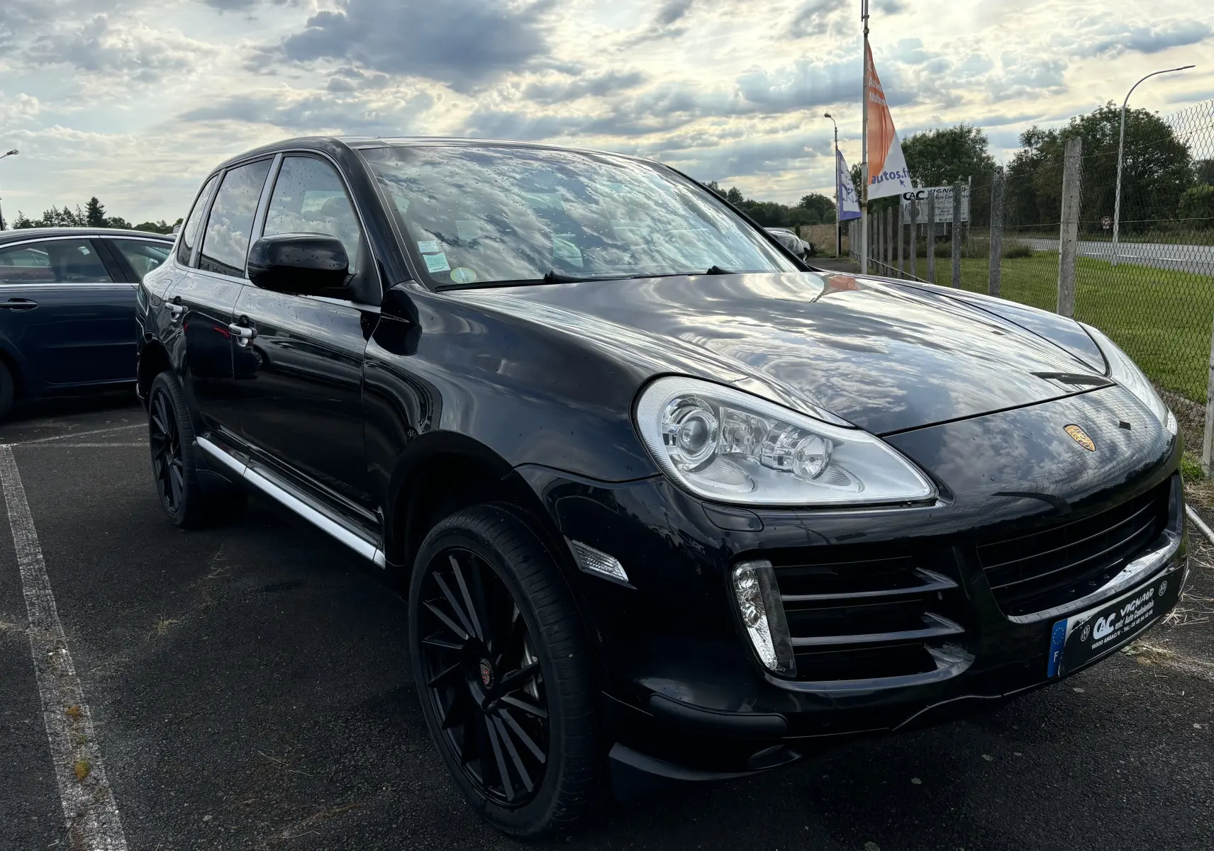 Vue 3/4 avant gauche d'un Porsche Cayenne S noir 2007 avec jantes noires et calandre caractéristique.