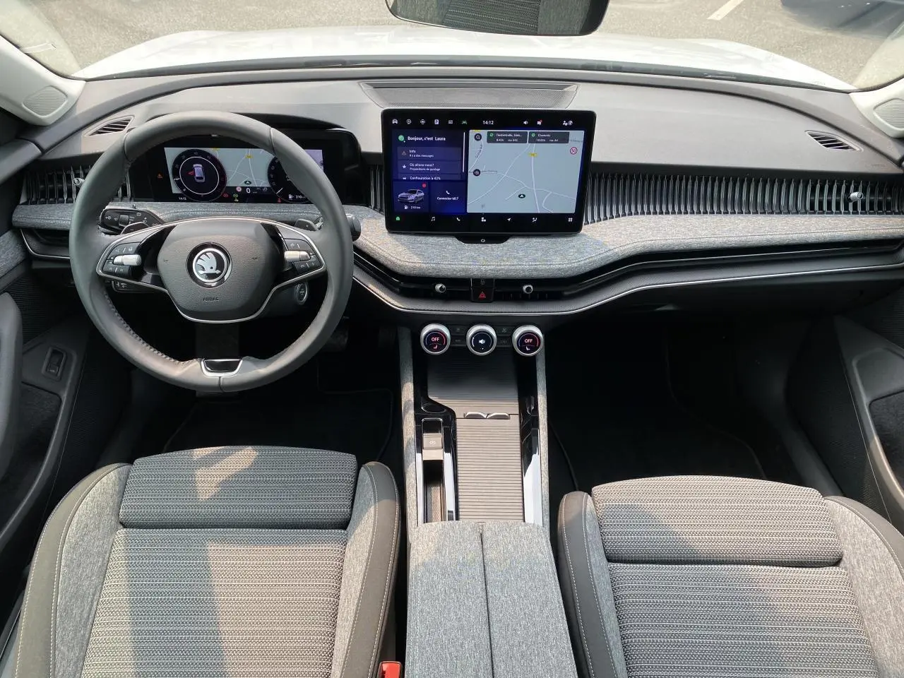 Intérieur de la Skoda Superb Combi 2024 vu de face, tableau de bord moderne avec écran tactile et volant multifonction noir.