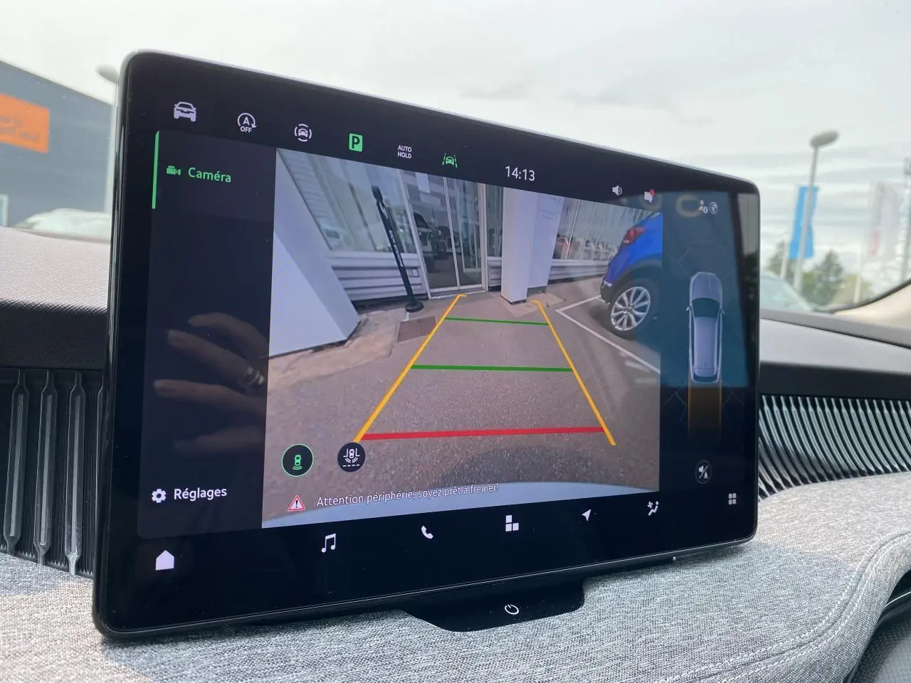 Écran tactile intérieur montrant la caméra de recul du Skoda Superb Combi blanc pure avec guidage coloré au sol.