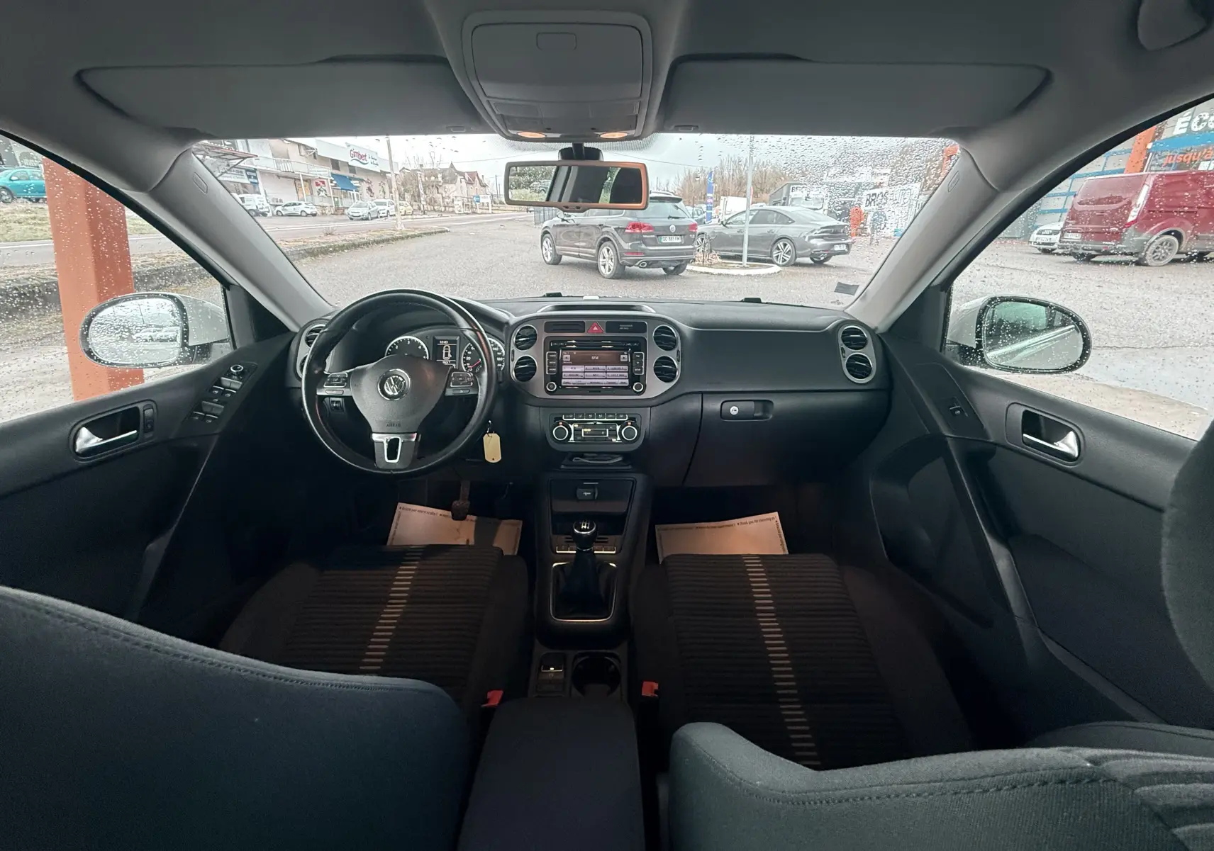 Vue intérieure avant du Volkswagen Tiguan 2.0 TDI blanc de 2010, tableau de bord et volant multifonction visibles.