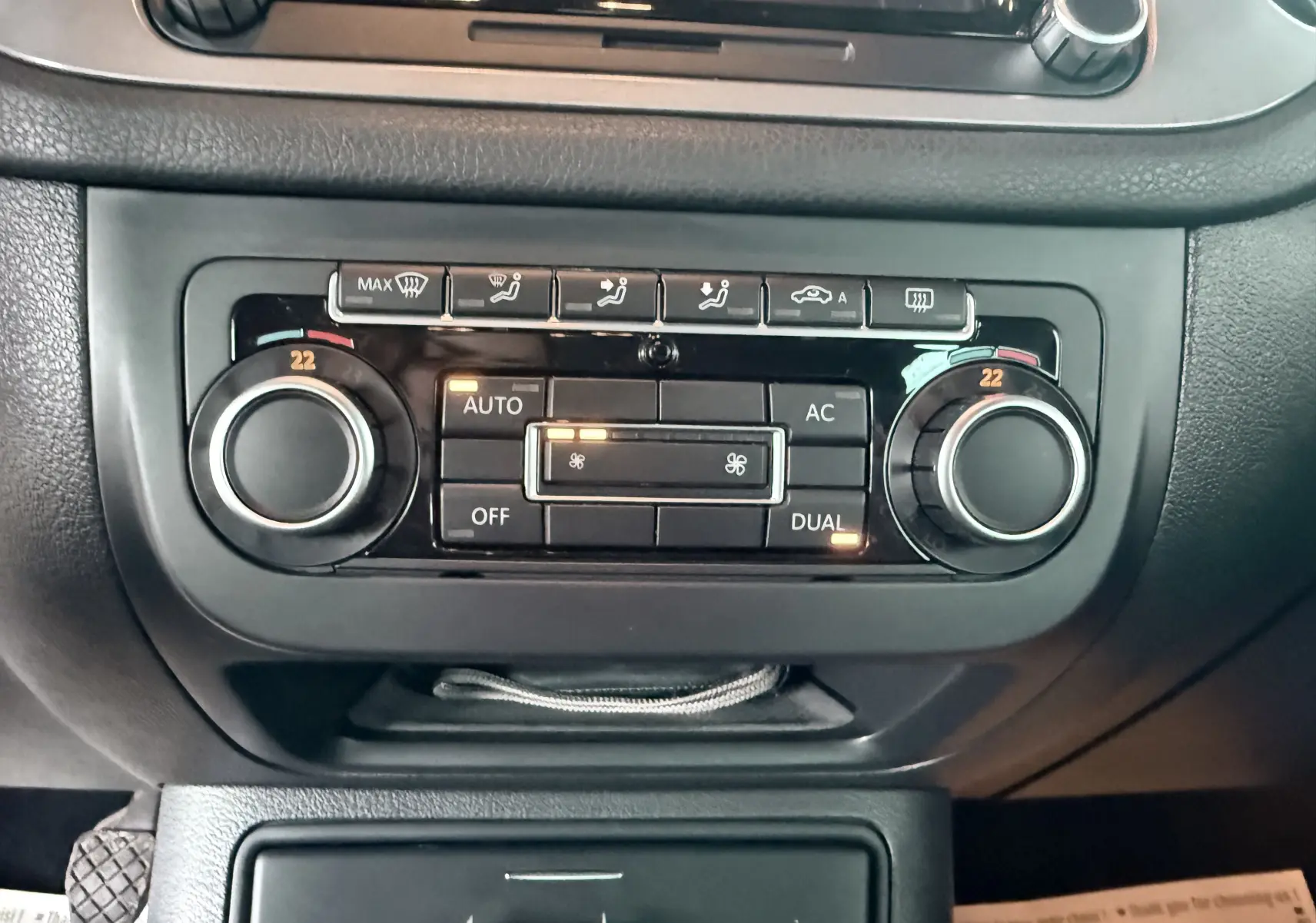 Gros plan sur la commande de climatisation automatique du Volkswagen Tiguan blanc, avec réglages à 22 degrés visibles.