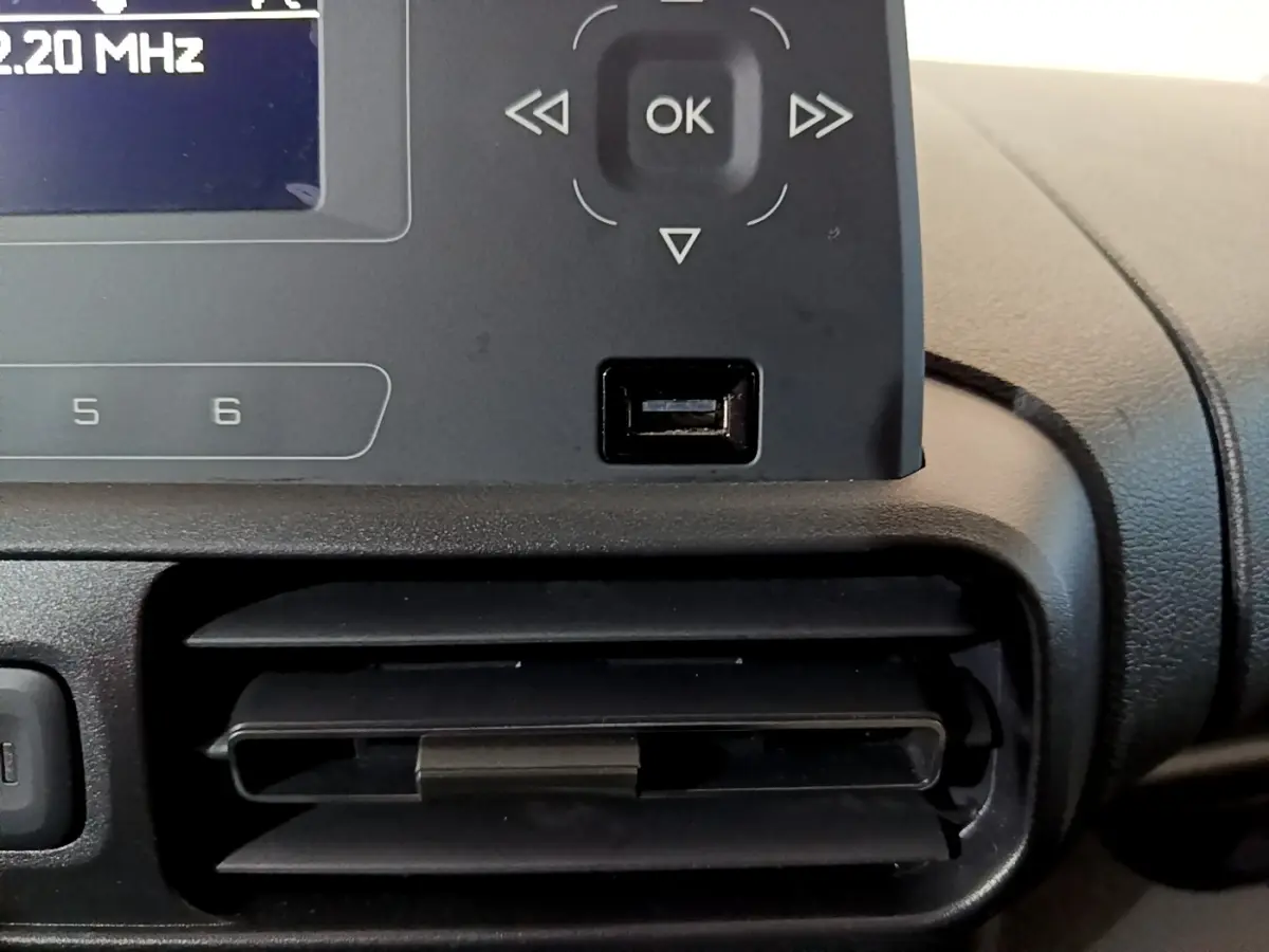 Détail de la console centrale noire du Citroën Berlingo XL 2019, avec écran radio et prise USB visible.