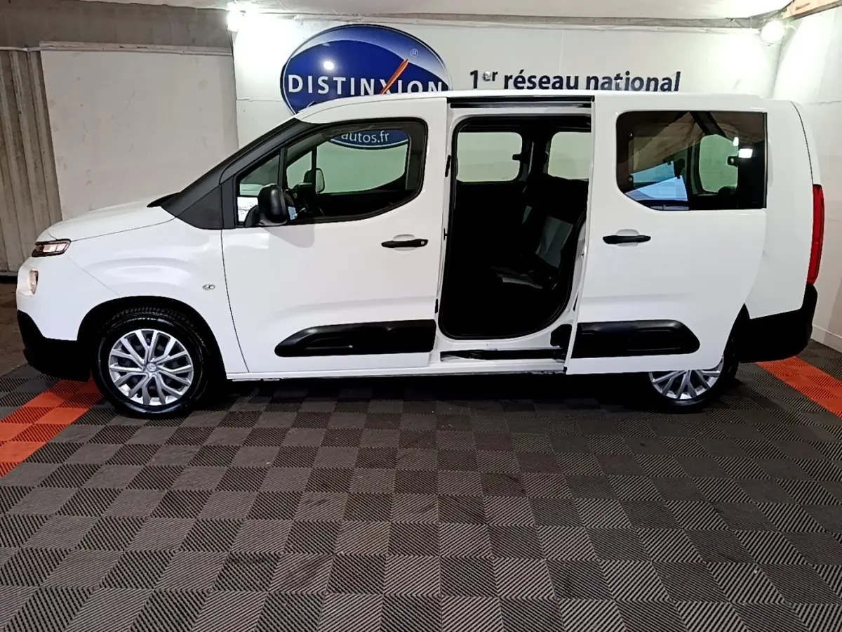 Vue latérale droite du Citroën Berlingo XL blanc 2019 avec porte coulissante ouverte, jantes alliage et protections noires.