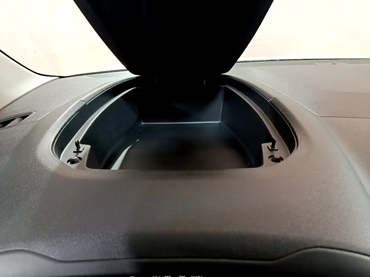 Coffre de rangement ouvert sur le tableau de bord noir du Citroën Berlingo XL blanc, vue intérieure frontale rapprochée.