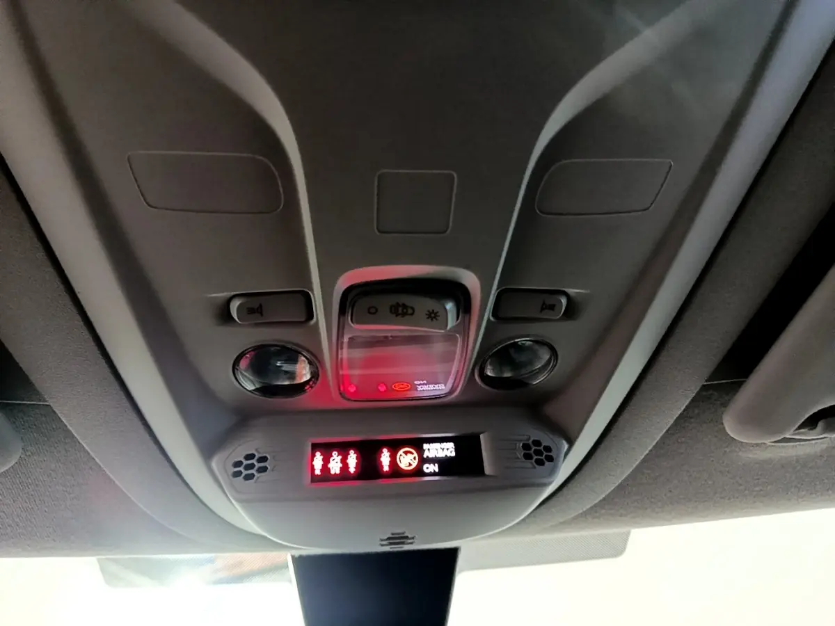 Vue intérieure du plafonnier gris avec commandes d’éclairage et affichage des ceintures de sécurité allumées.