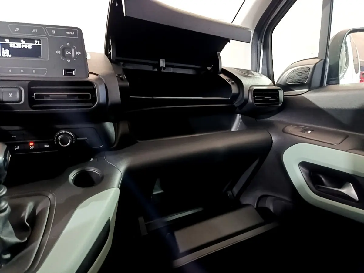 Vue intérieure côté passager du tableau de bord noir et gris avec boîte à gants ouverte du Citroën Berlingo XL blanc 2019.