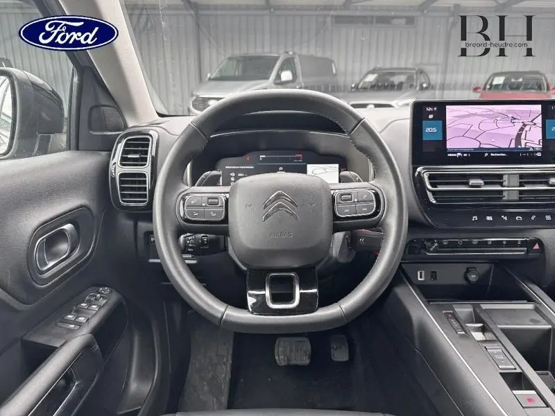 Vue intérieure centrée sur le volant cuir multifonction du Citroën C5 Aircross 2023, avec écran tactile et tableau de bord numérique.