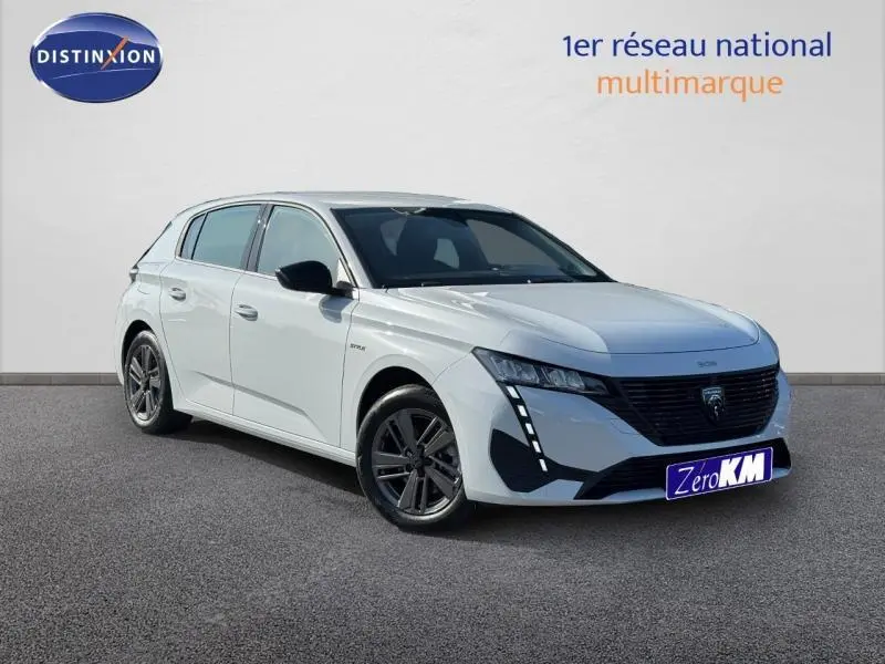 Peugeot 308 blanc Okénite vue 3/4 avant gauche, avec calandre noire et feux LED verticaux distinctifs.