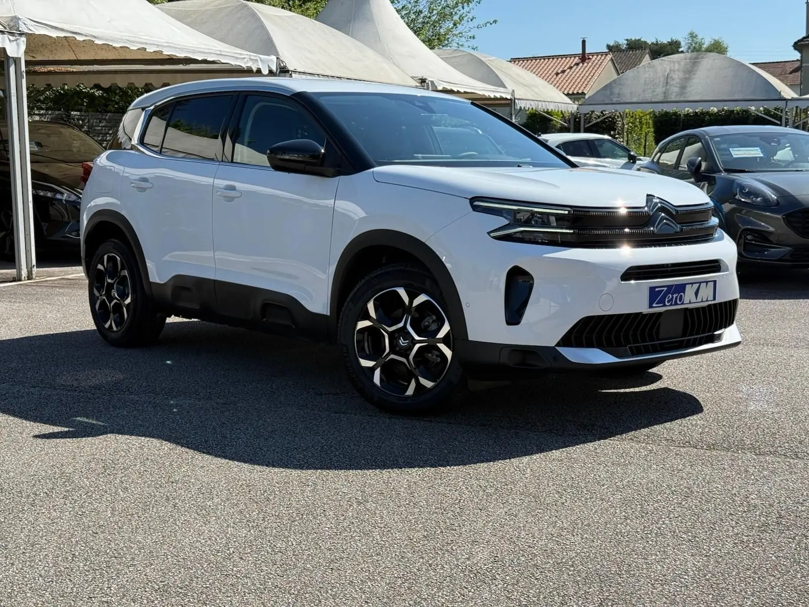 Citroën C5 Aircross blanc banquise en 3/4 avant droit avec jantes bi-ton et toit noir contrasté.