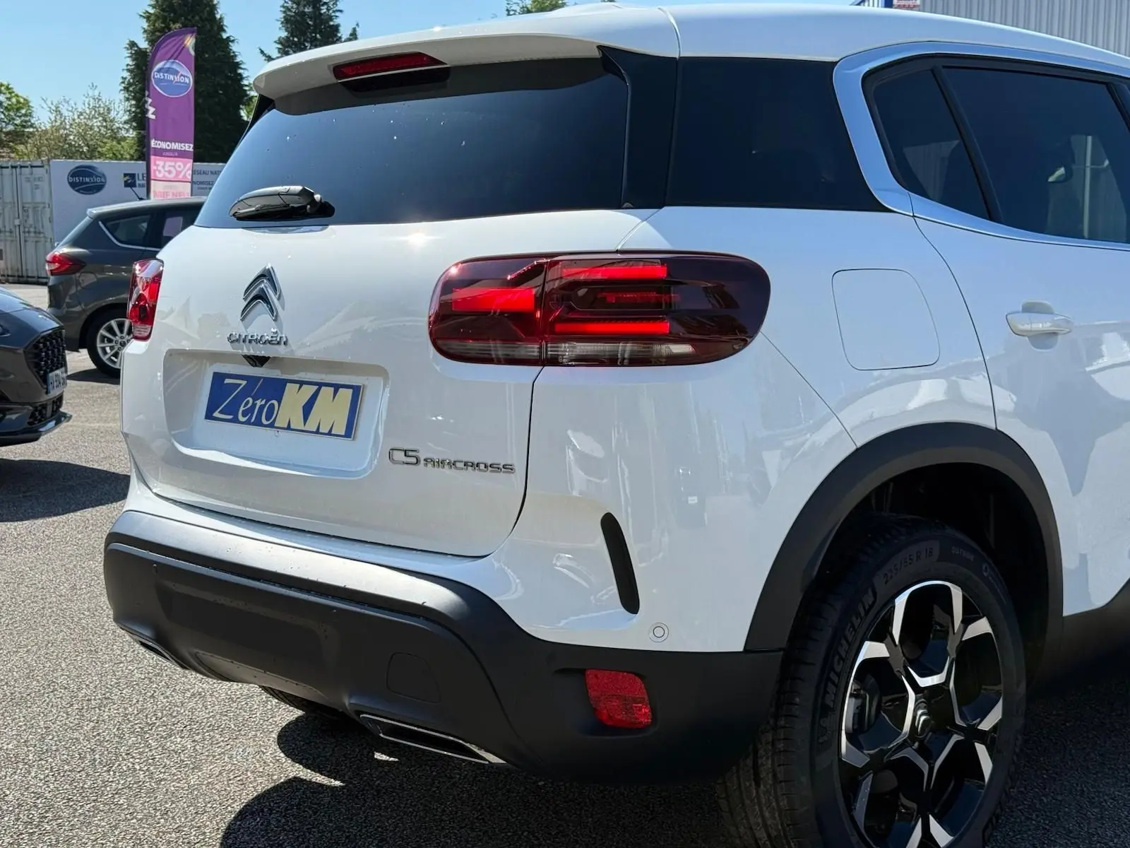 Vue 3/4 arrière droite d'un Citroën C5 Aircross blanc banquise avec feux arrière LED et jantes bi-ton 18 pouces.