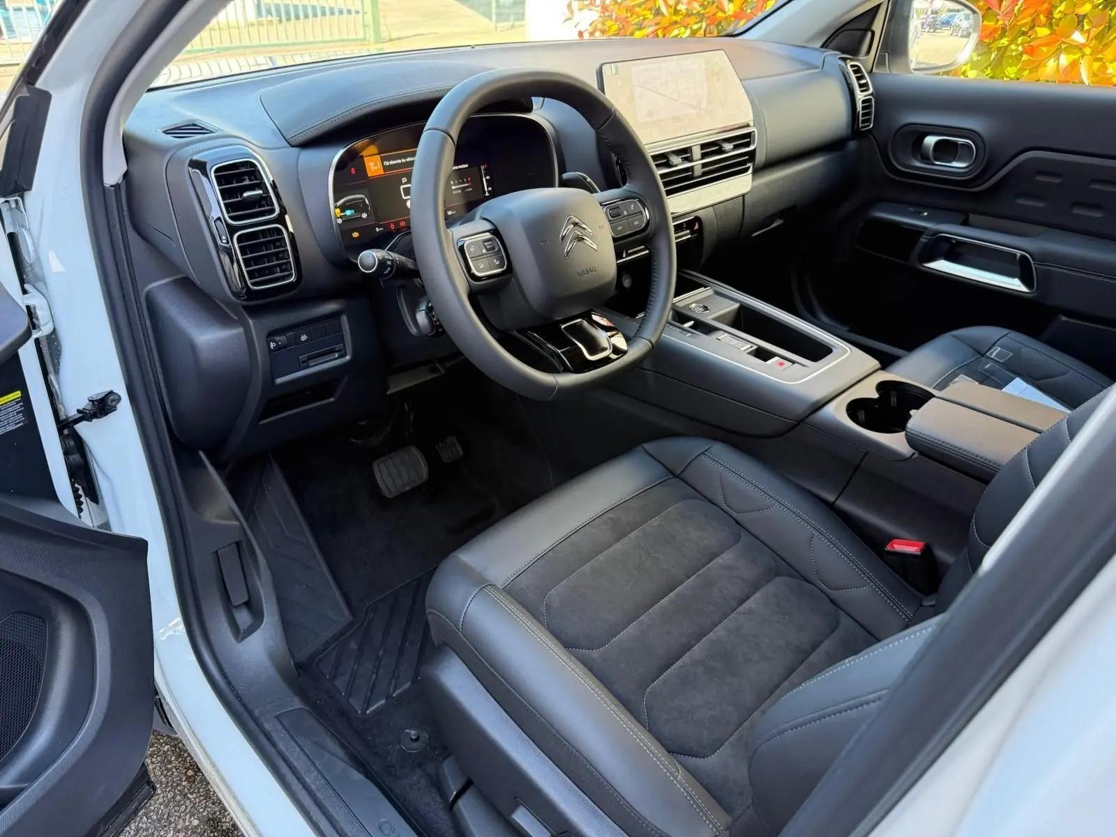 Intérieur côté conducteur du Citroën C5 Aircross blanc banquise 2024, avec tableau de bord numérique et sièges en cuir noir.