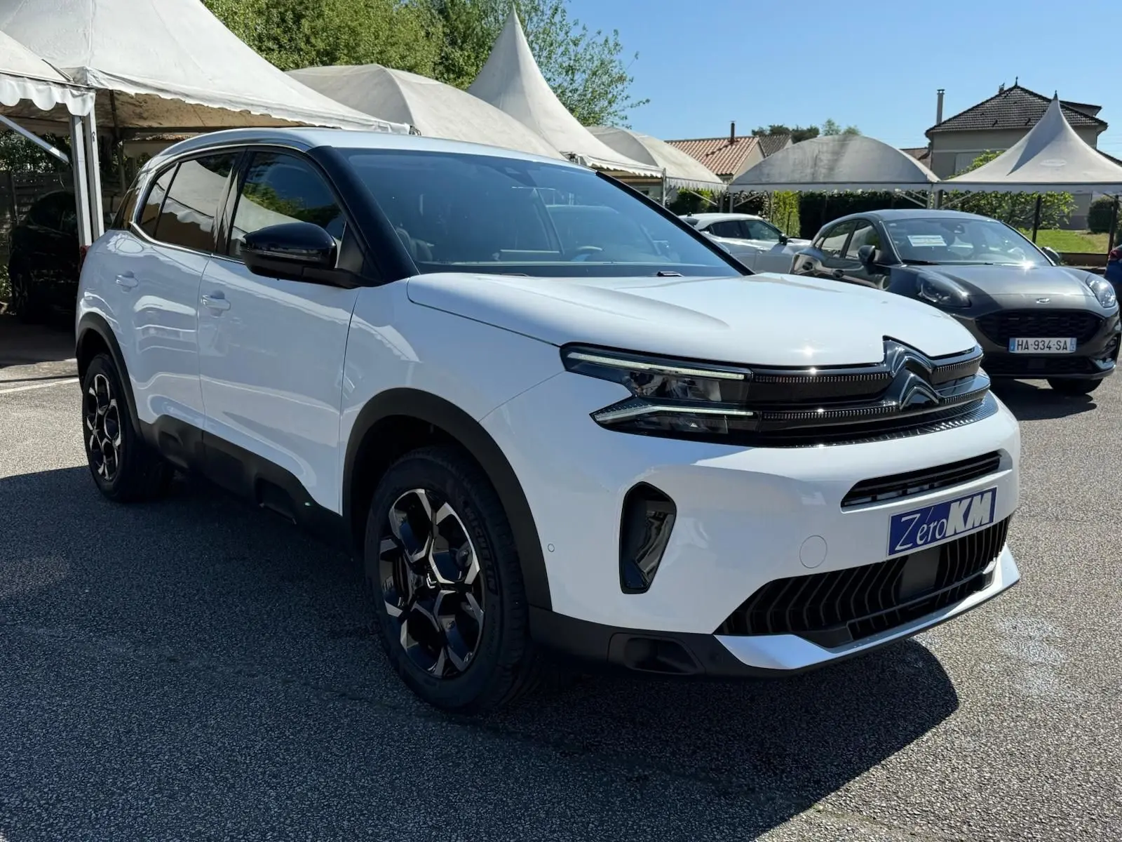 Citroën C5 Aircross blanc banquise en 3/4 avant droit, avec jantes noires et toit contrasté noir.