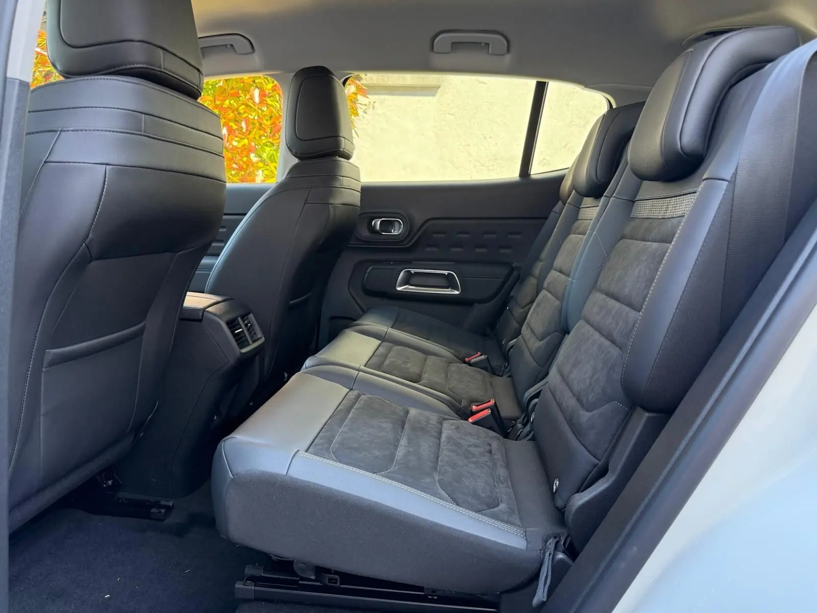 Vue latérale droite de l'habitacle arrière du Citroën C5 Aircross blanc banquise avec sièges en cuir noir et alcantara.